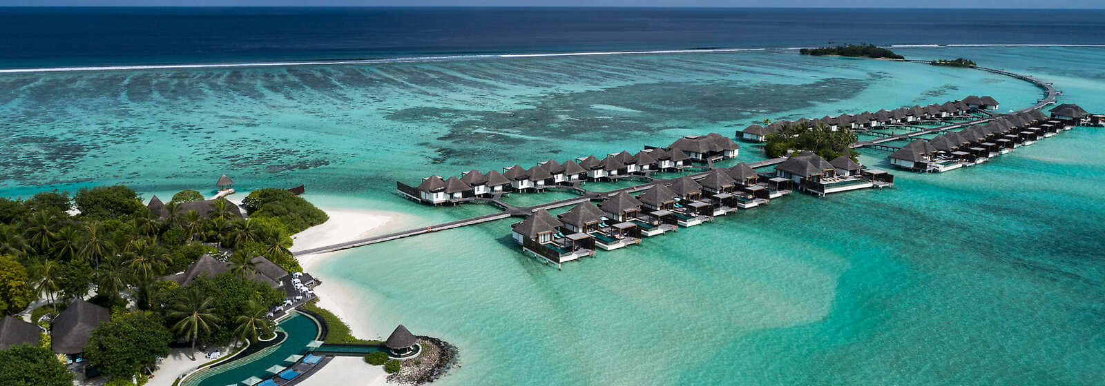 Maldives Island 桌布 壁紙 — 豪華水上平房的鳥瞰圖，位於碧綠色的潟湖上，擁有白色沙灘和棕櫚樹。