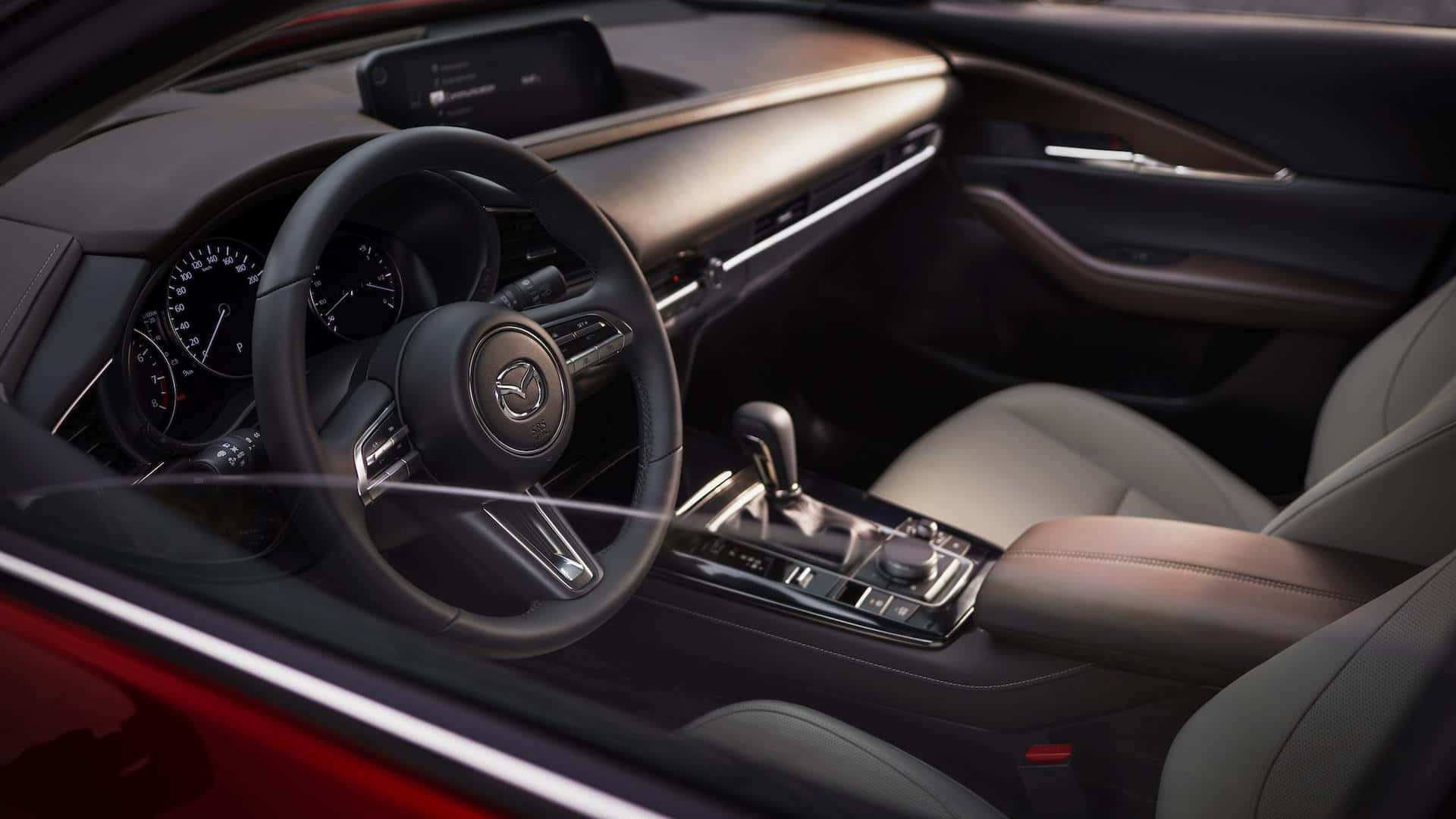 Mazda Cx-30 桌布 壁紙 — 豪華汽車內裝，配有黑色皮革座椅和時尚儀表板，在溫暖的環境照明下。