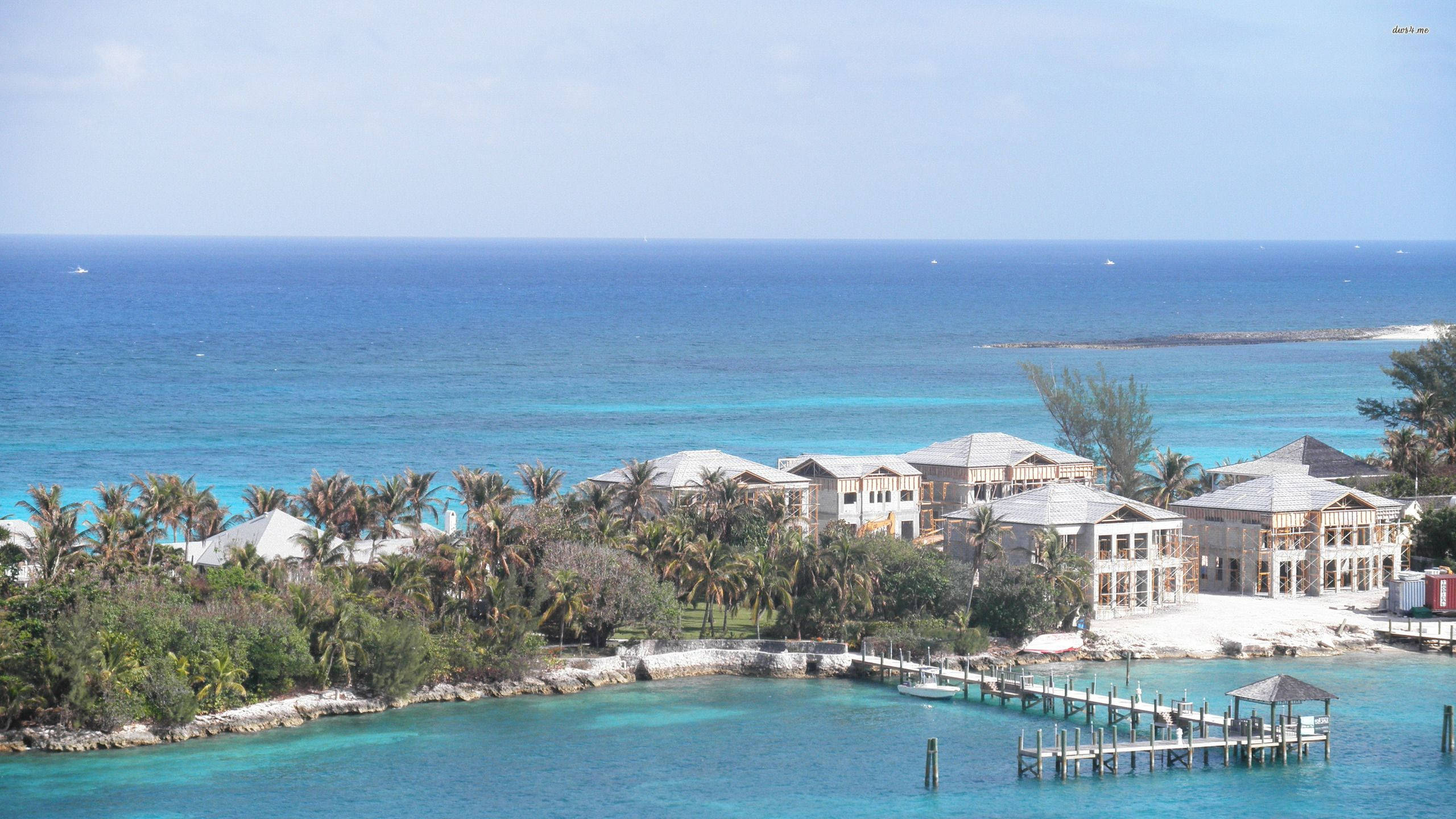 Nassau Bahamas 桌布 壁紙 — 豪華海濱別墅隱藏在棕櫚樹之間，擁有碧綠的海水和延伸至海洋的長碼頭。