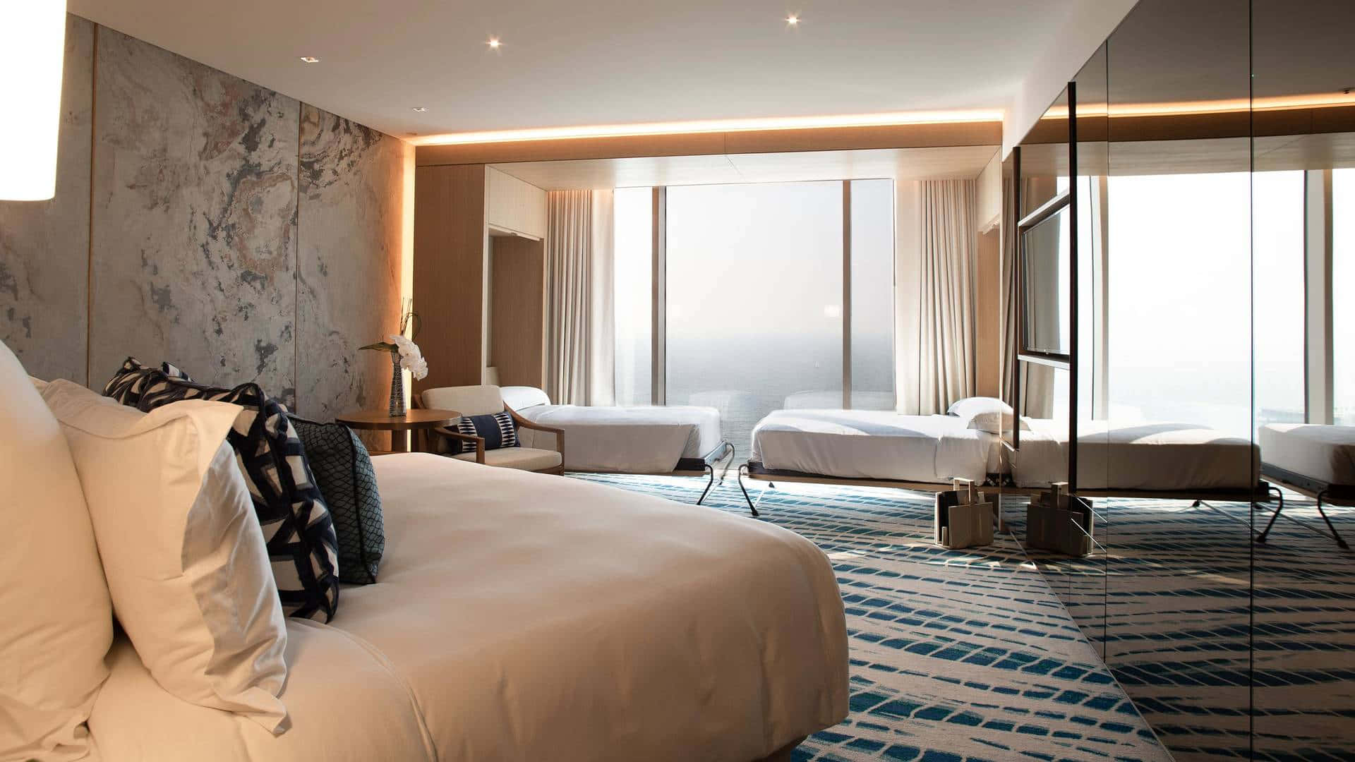 Interior Design 桌布 壁紙 — 豪華現代飯店客房，配備大床、大理石特色牆和落地窗，可欣賞明亮的城市景觀。