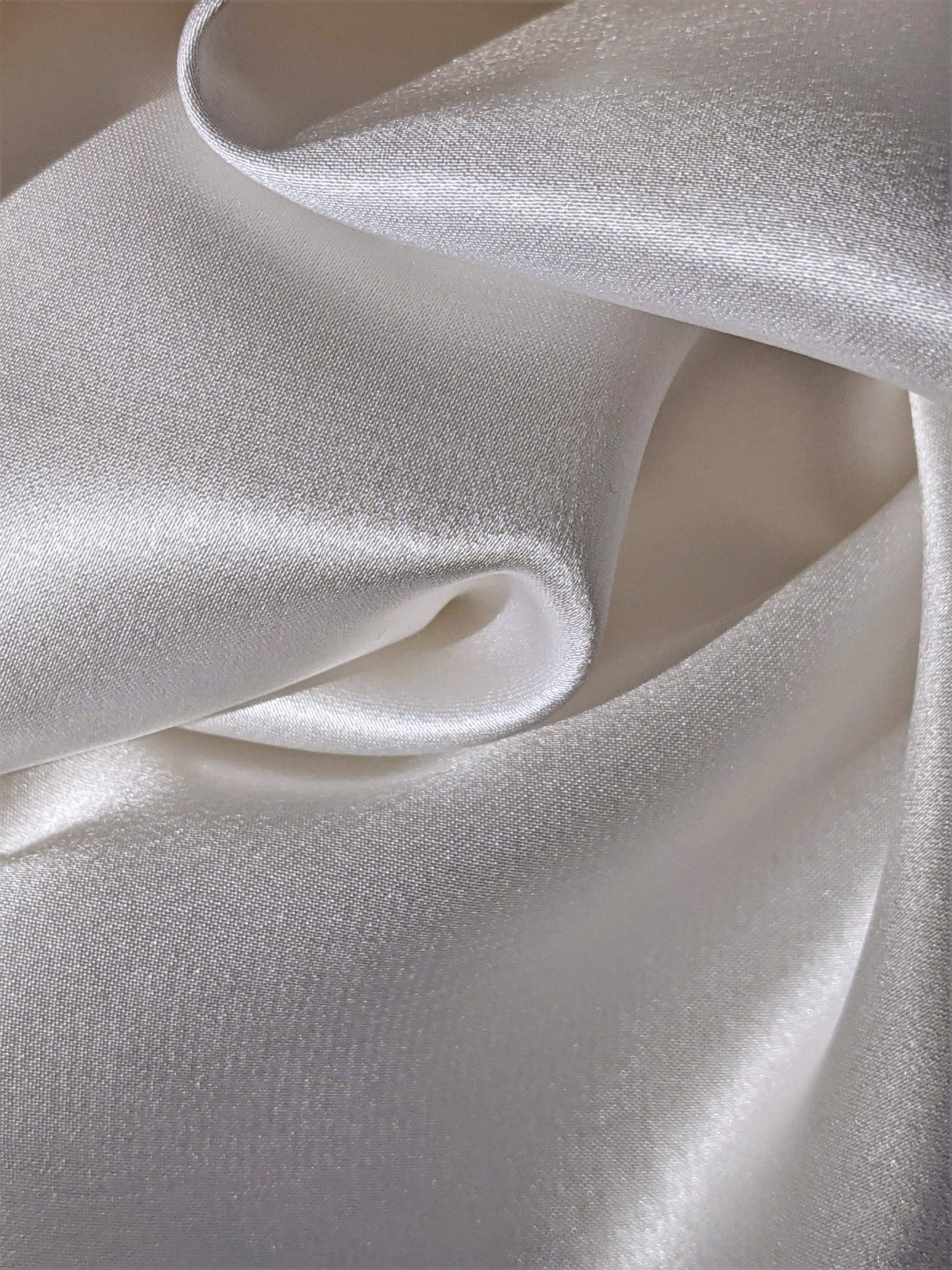 Silk 桌布 壁紙 — 豪華白色絲綢布料特寫，帶有柔軟皺褶和柔和光澤，在柔和燈光下。