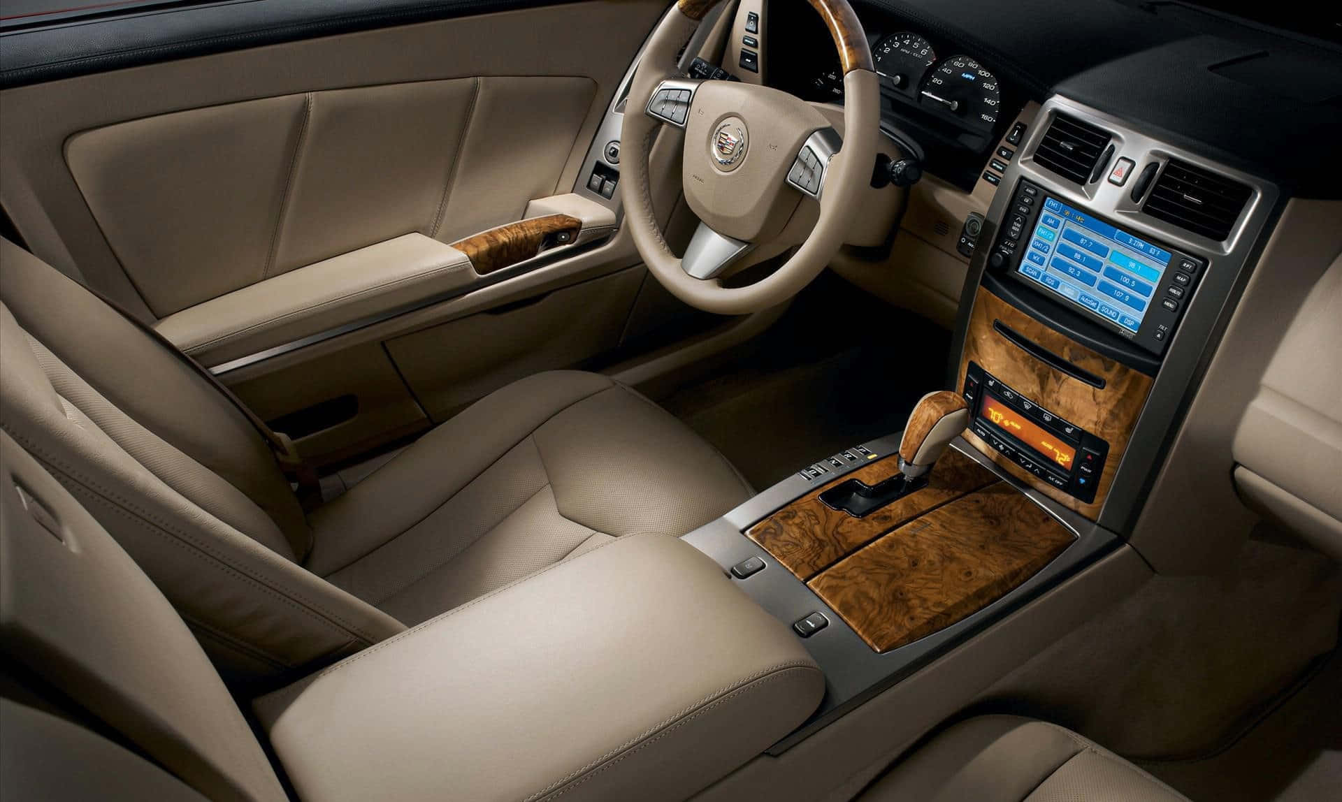 Cadillac Xlr 桌布 壁紙 — 豪華米色皮革汽車內裝，搭配木質飾邊和數位顯示屏，在環境照明下溫暖發光。