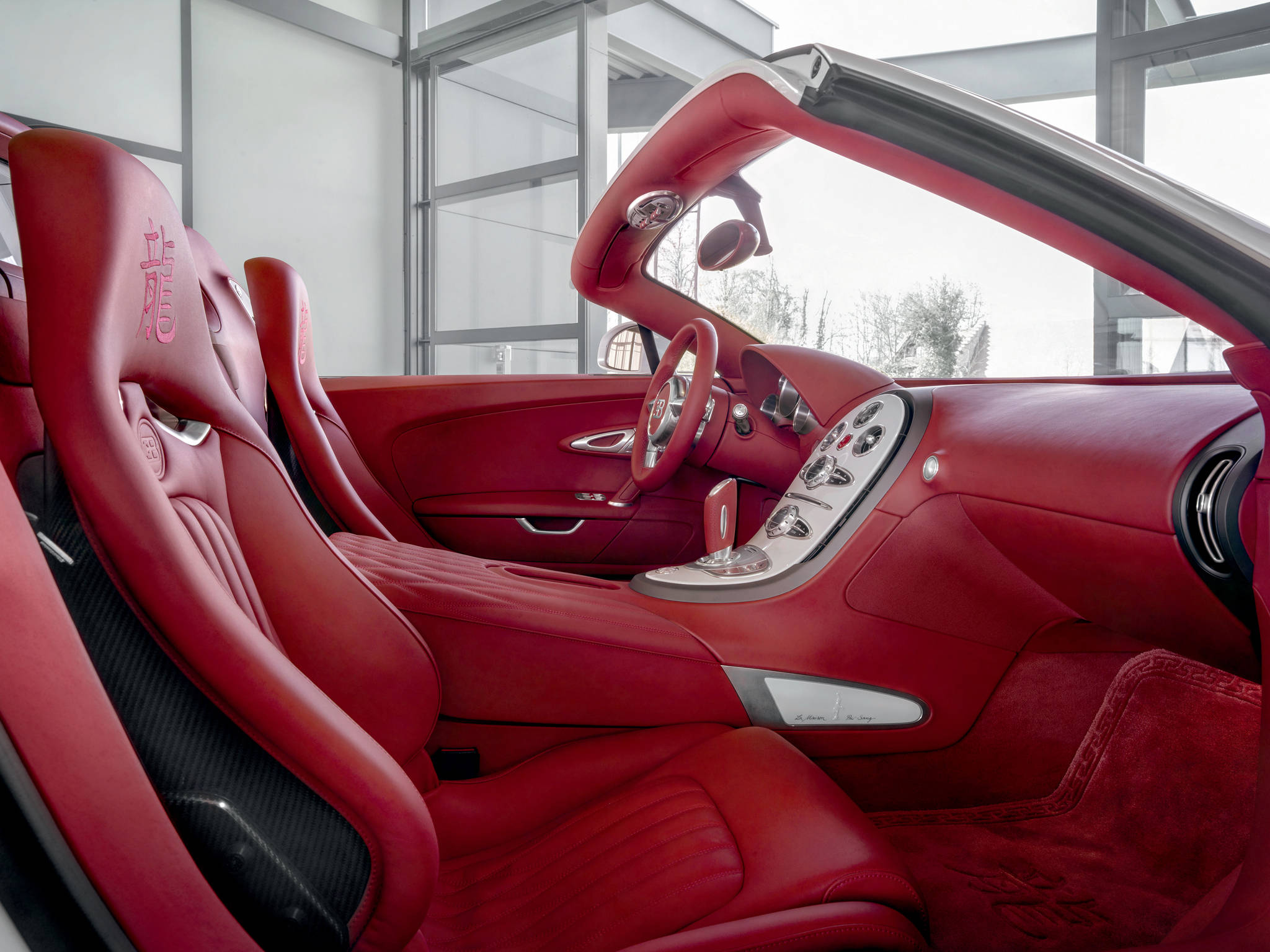 bugatti iPhone 桌布 壁紙 — 豪華紅色皮革內飾的敞篷跑車，配備碳纖維飾邊和鍍鉻細節。