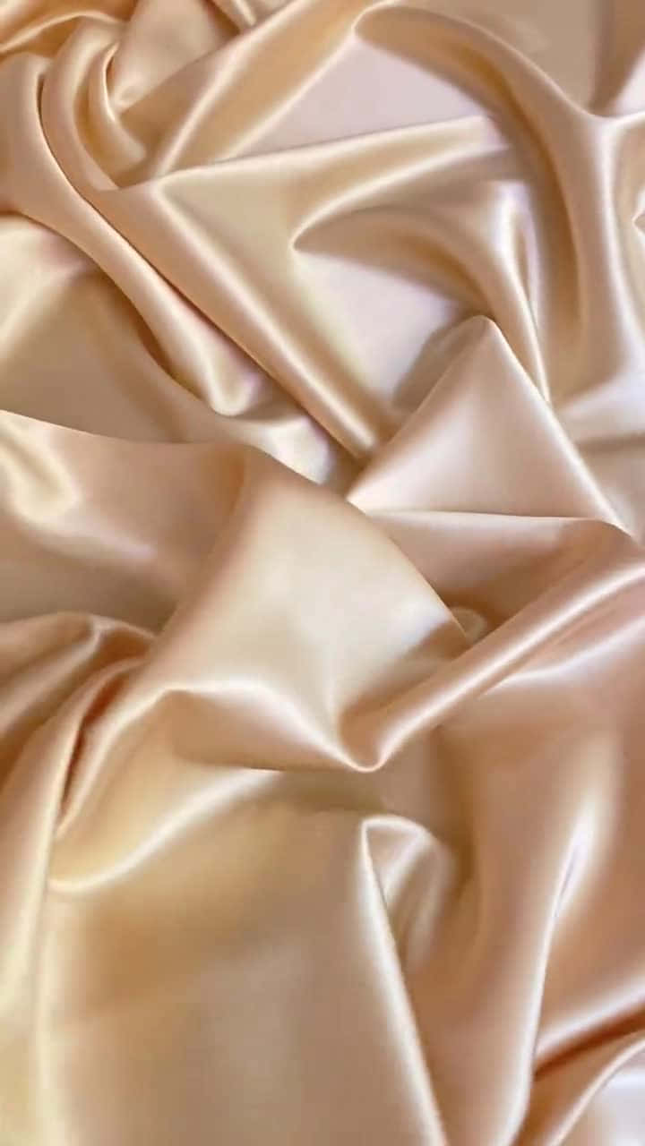 Gold Silk 桌布 壁紙 — 豪華蜜桃色緞面布料的特寫，帶有柔軟的褶皺和柔和的高光。