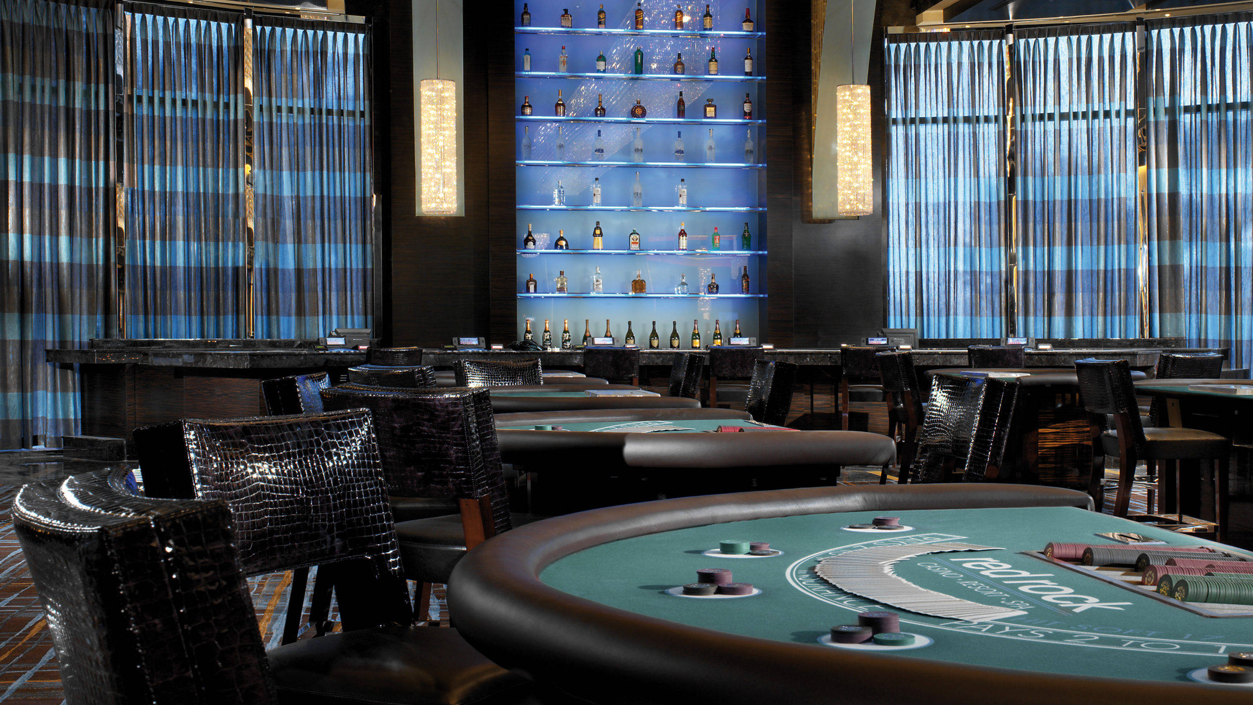 Poker 桌布 壁紙 — 豪華賭場房間，設有綠色撲克桌、鱷魚皮椅和發光的藍色瓶子牆。