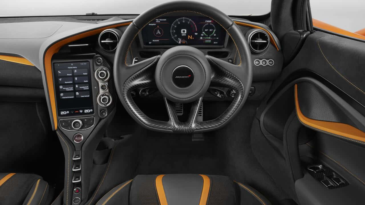 Steering Wheel 桌布 壁紙 — 豪華跑車內裝，配備黑色碳纖維方向盤、數位儀表板及橙色縫線點綴。