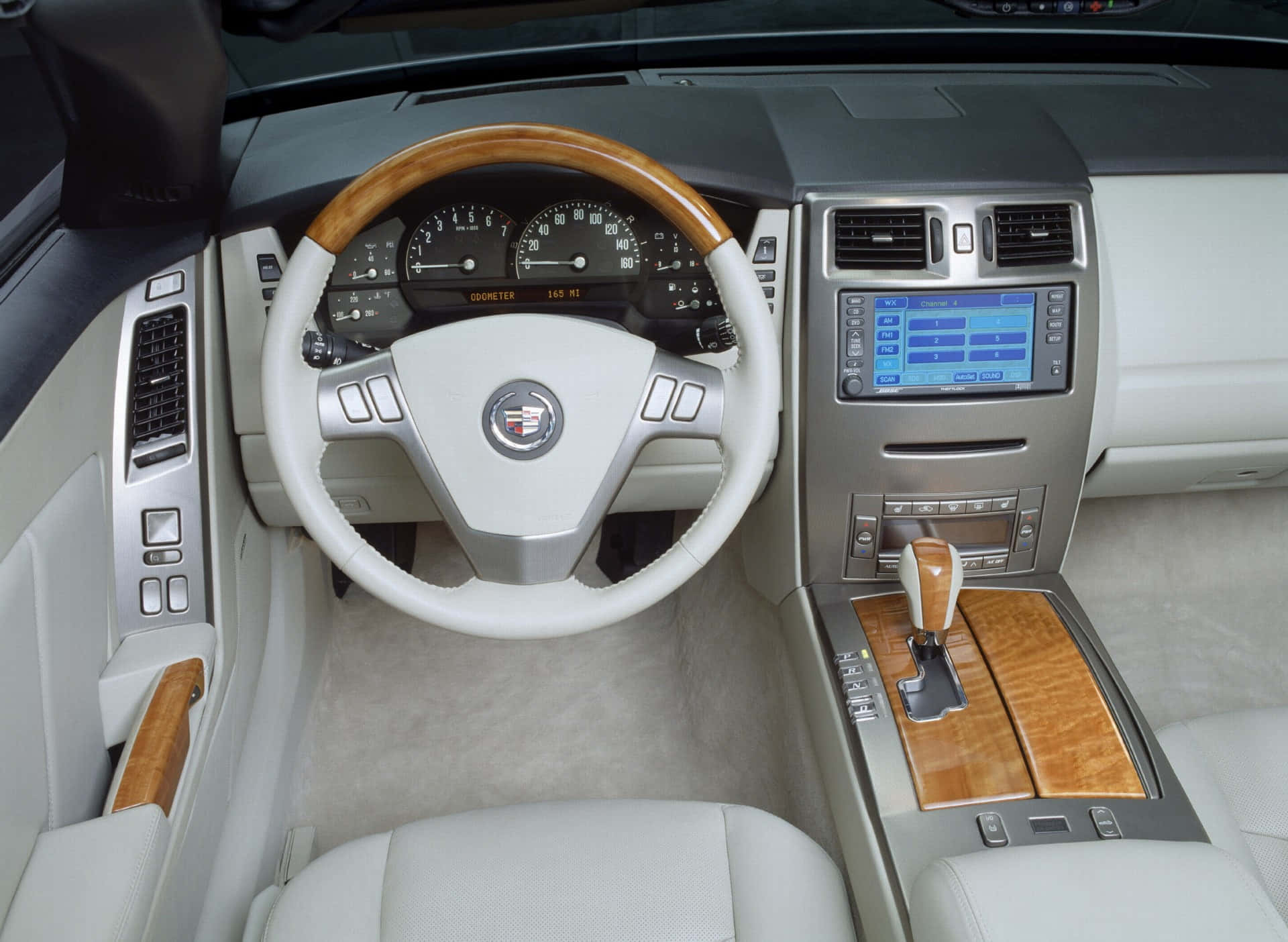 Cadillac Xlr 桌布 壁紙 — 豪華車內裝，配備白色皮革座椅、木質飾板和數位顯示螢幕。