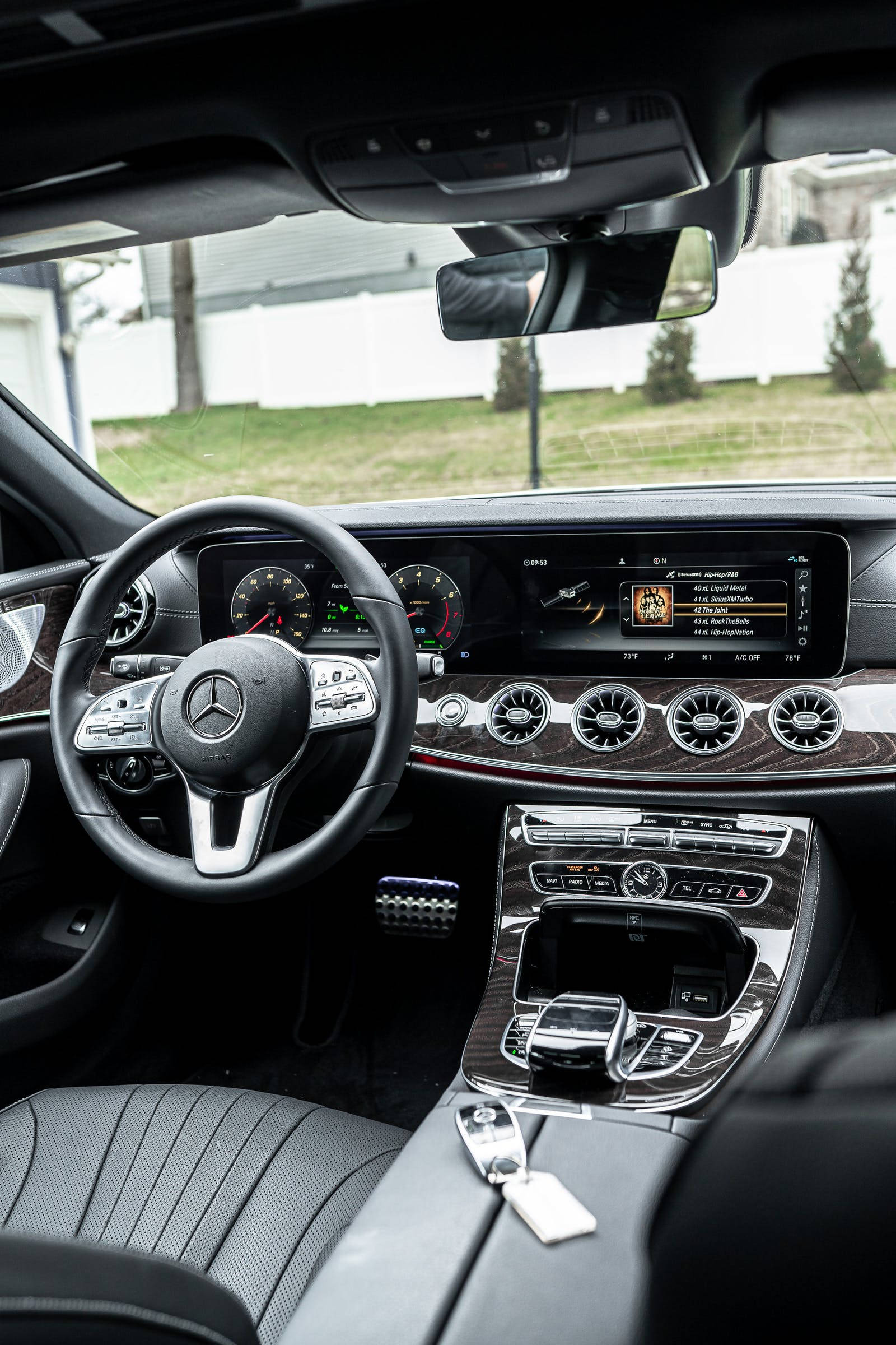 Luxury 桌布 壁紙 — 豪華車內裝，配備黑色真皮座椅、木飾邊和顯示音樂播放器的數位儀表板。