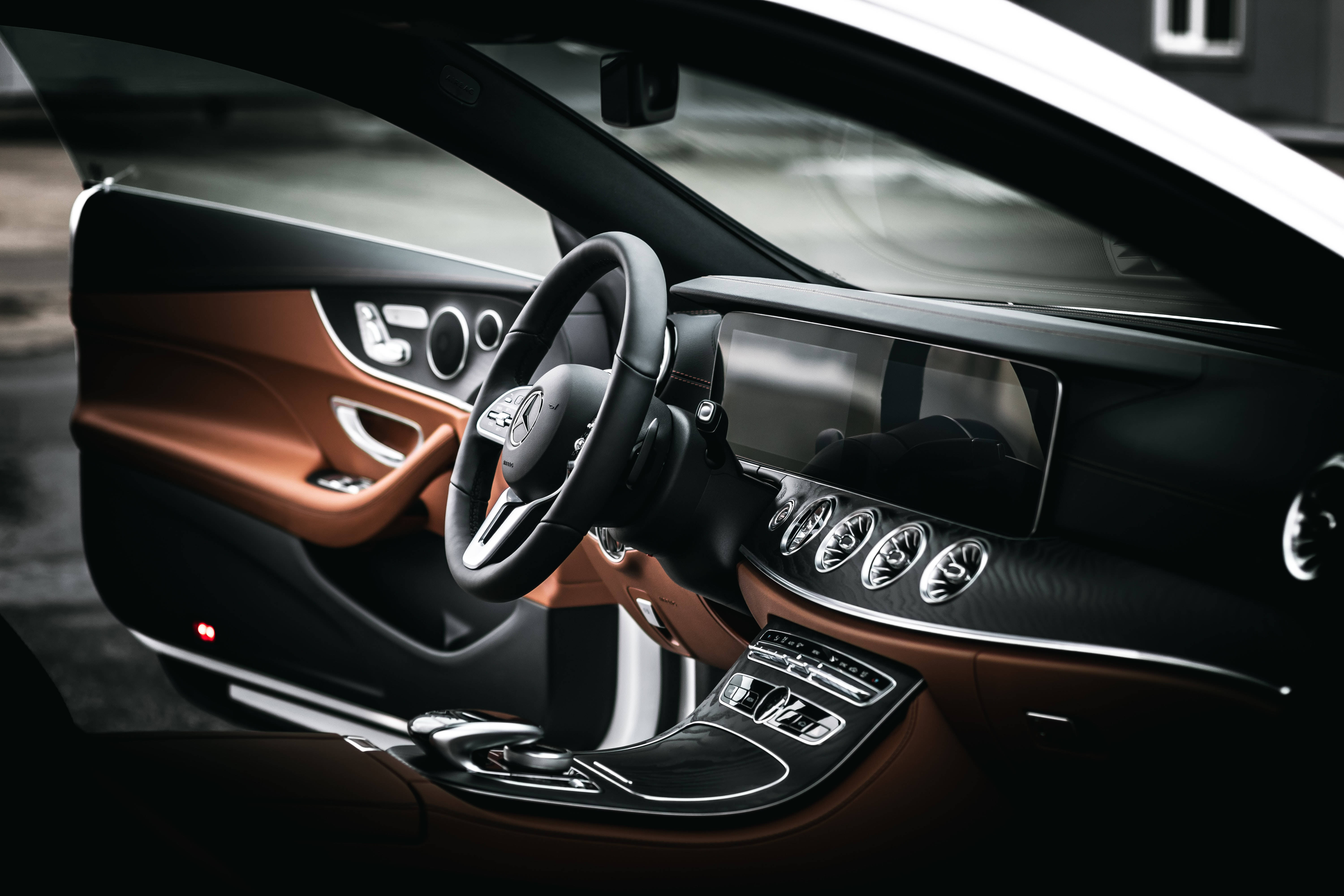Mercedes 桌布 壁紙 — 豪華車內裝，黑色和銅色點綴，展示時尚儀表板和方向盤。