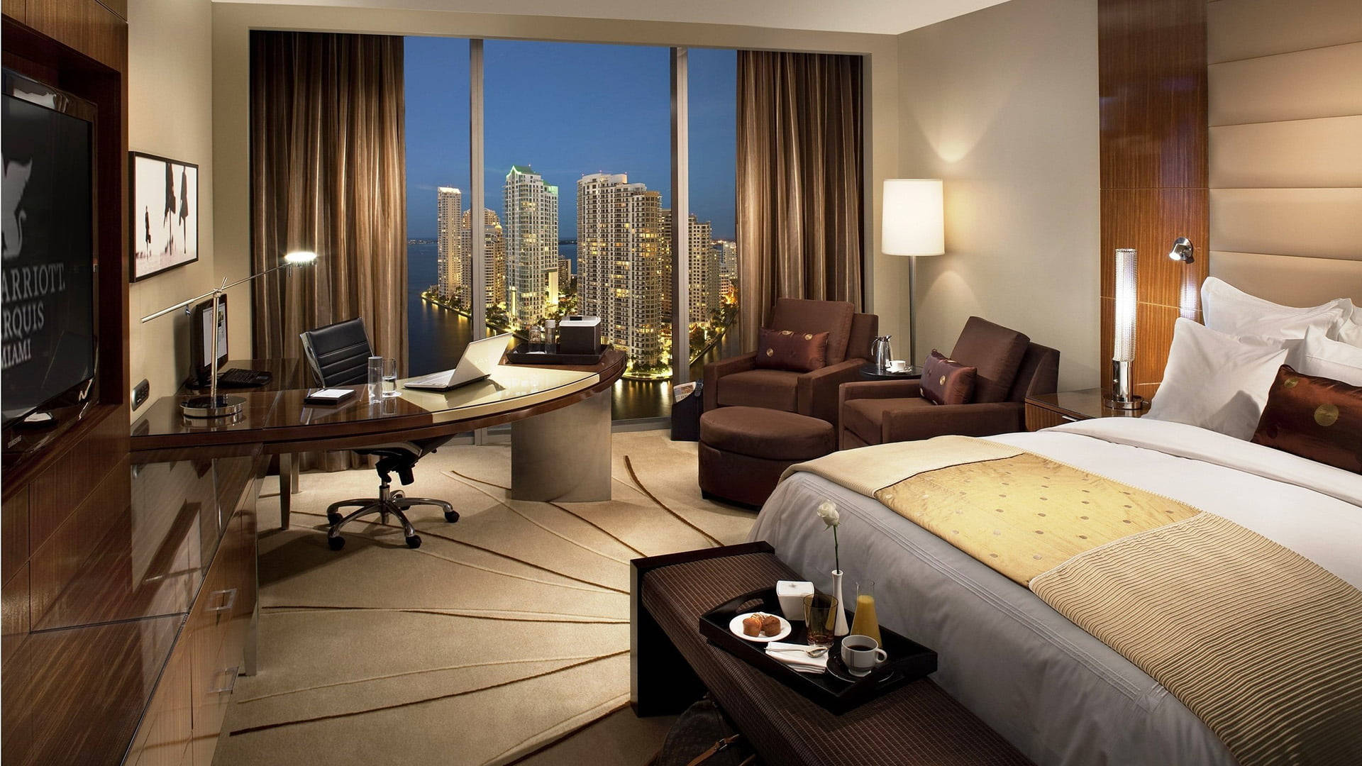 Interior Design 桌布 壁紙 — 豪華酒店套房夜景，可欣賞城市天際線和現代家具。