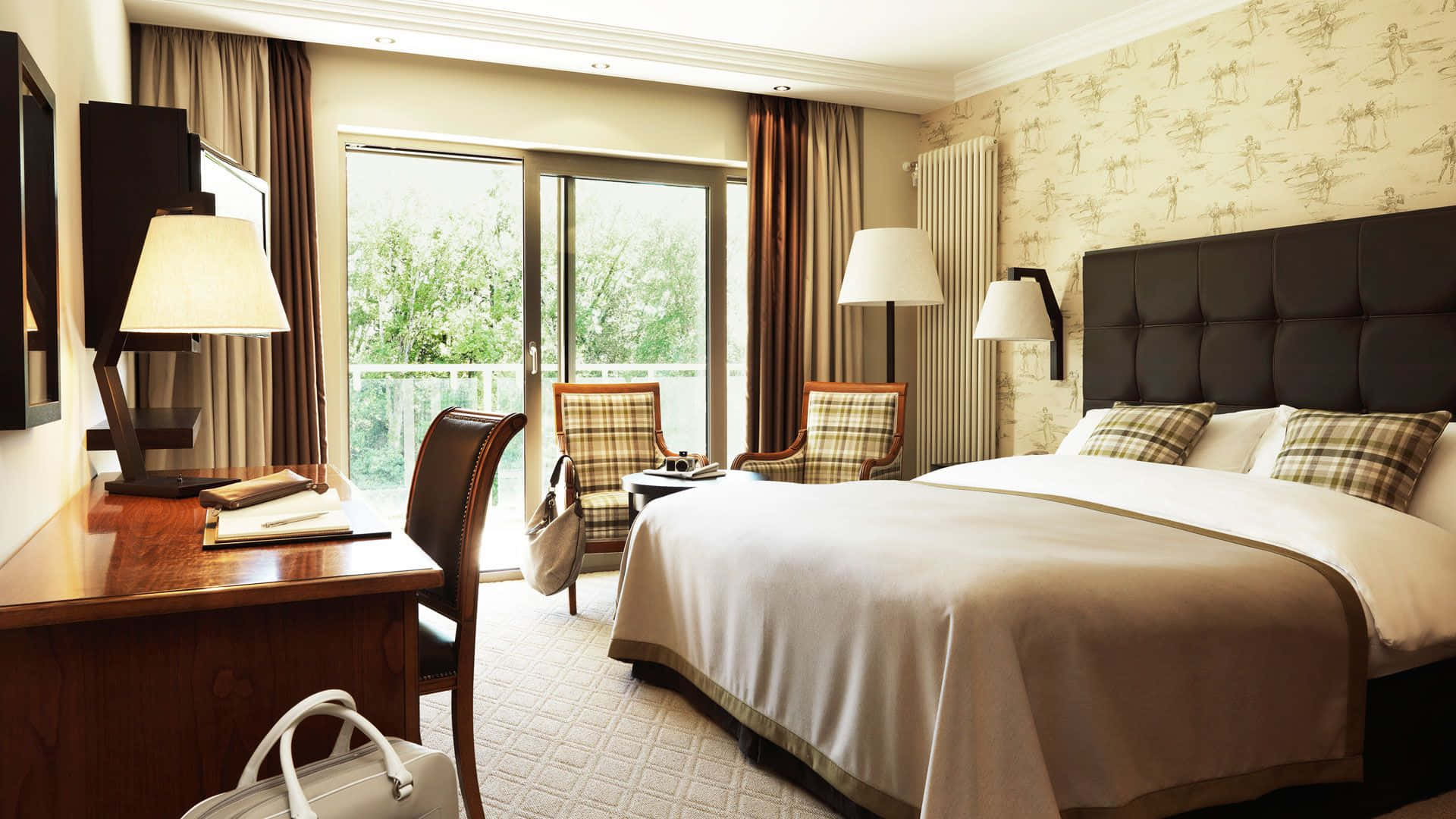 Hotel Room 桌布 壁紙 — 豪華飯店客房，配備一張大床、圖案壁紙和一個可俯瞰綠意的陽台。