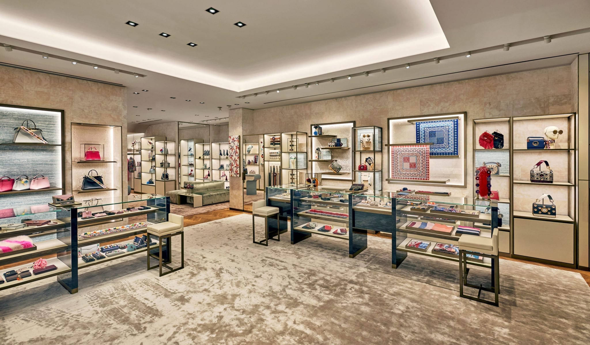 Fendi 桌布 壁紙 — 豪華高級精品店內部，設有玻璃展示櫃，在溫暖的環境燈光下展示手提包、鞋子和配件。