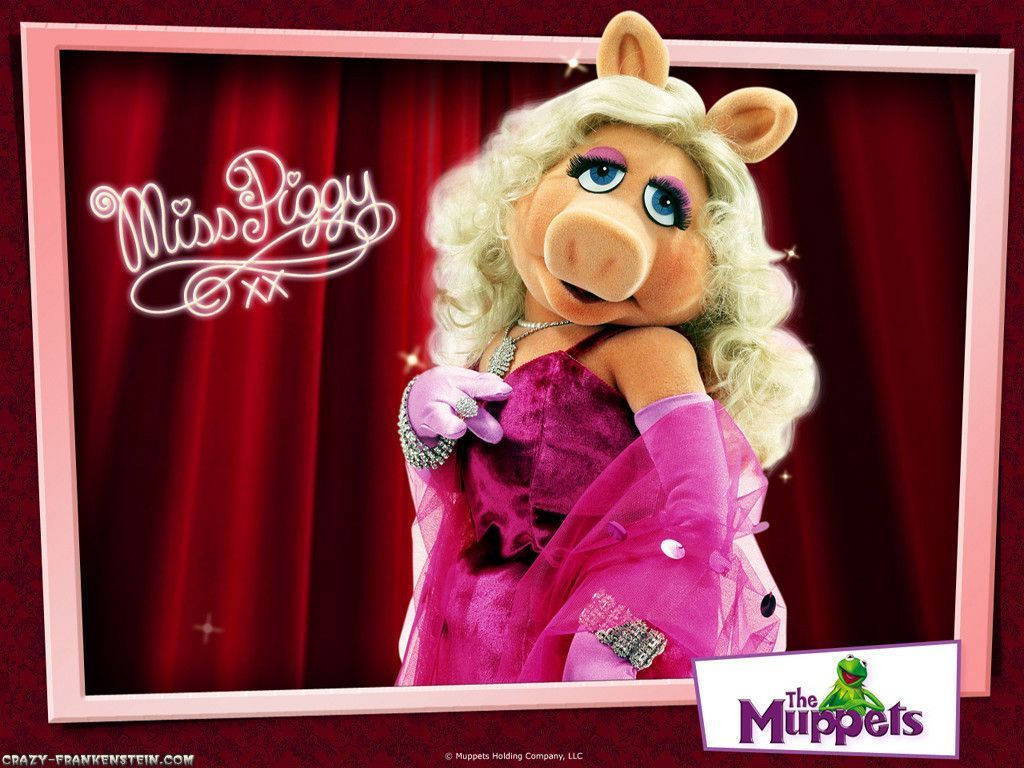 Miss Piggy 桌布 壁紙 — 豬小姐身穿華麗粉紅色長裙，在紅色帷幕背景前自信地擺姿勢，配以閃爍的相框。