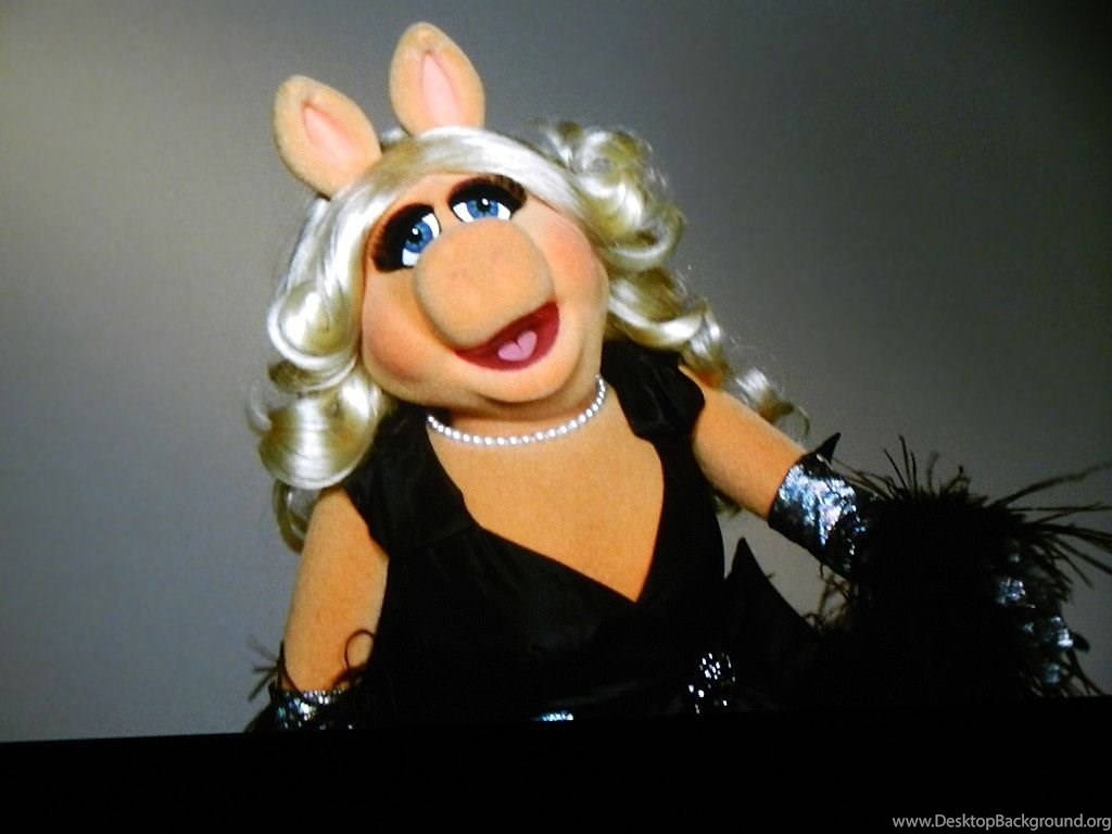 Miss Piggy 桌布 壁紙 — 豬小姐身穿迷人黑色連衣裙，佩戴珍珠項鍊和羽毛圍巾，在純灰色背景前自信微笑。