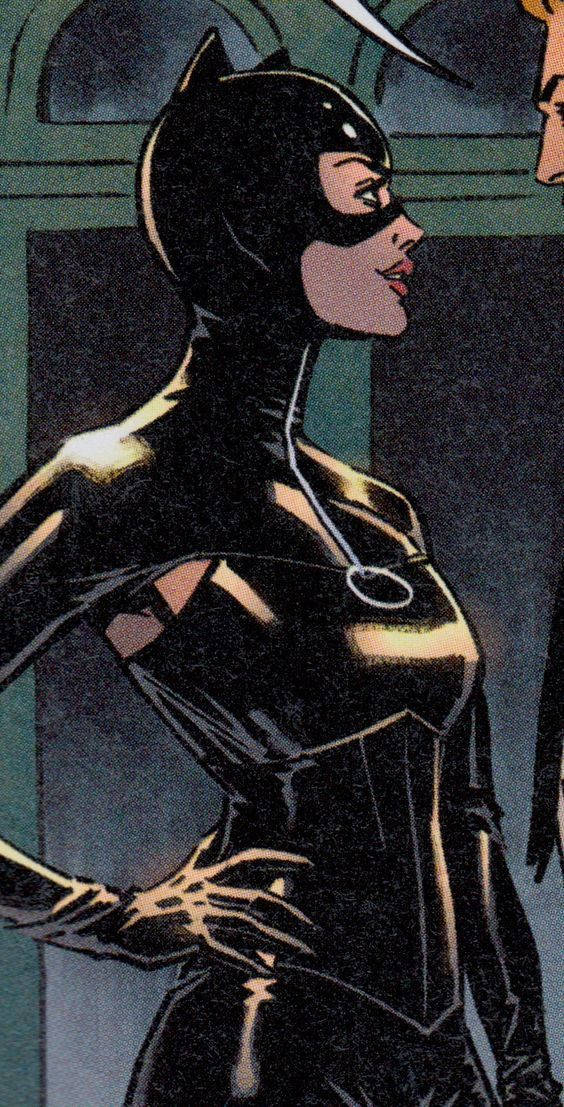 Catwoman 桌布 壁紙 — 貓女郎身穿時尚黑色緊身衣，一手叉腰，站在燈光昏暗的門口。