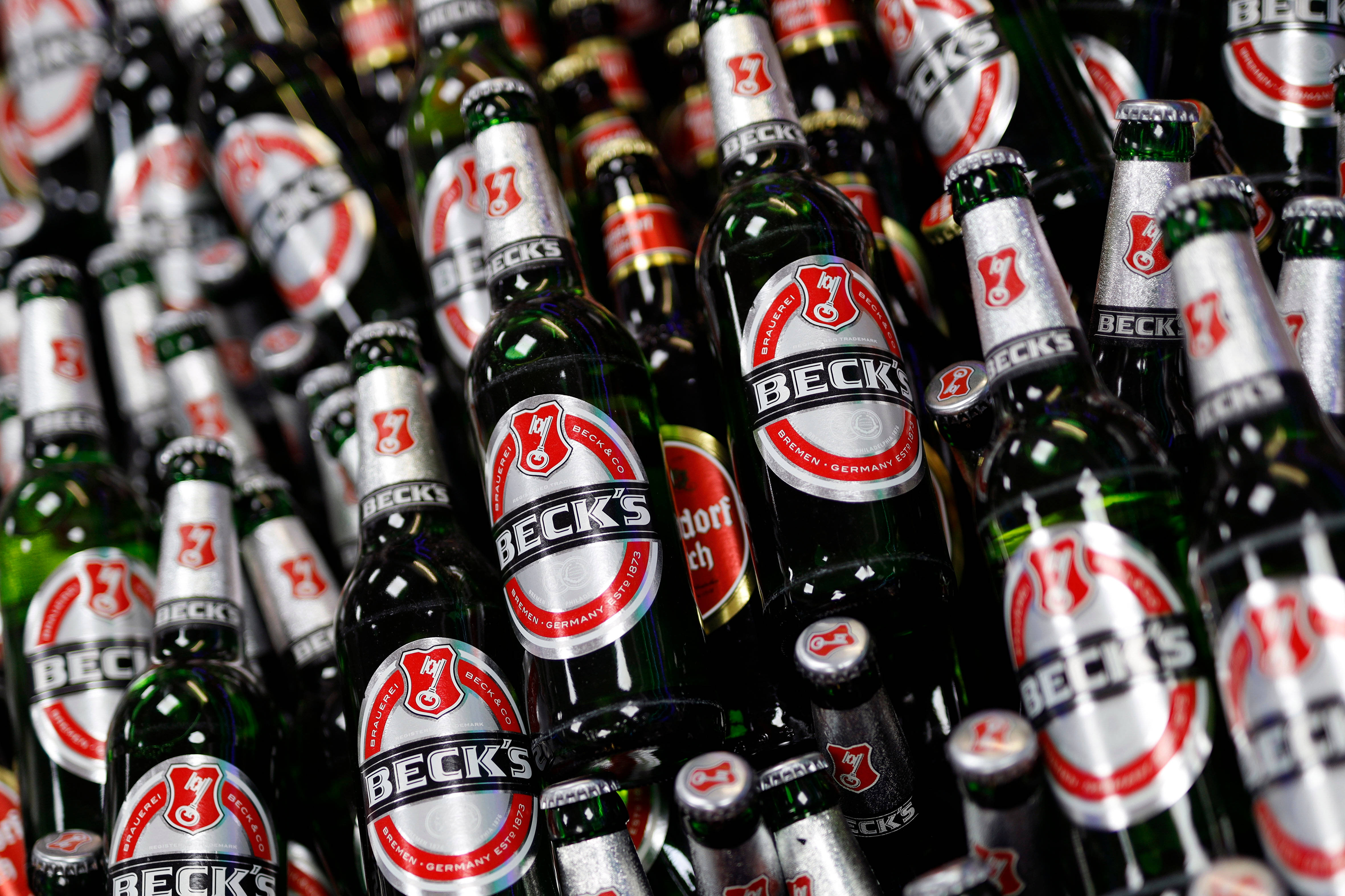 Beer 桌布 壁紙 — 貝克啤酒瓶的密集特寫，帶有銀色和紅色標籤，緊密排列並以角度呈現出充滿活力的展示。