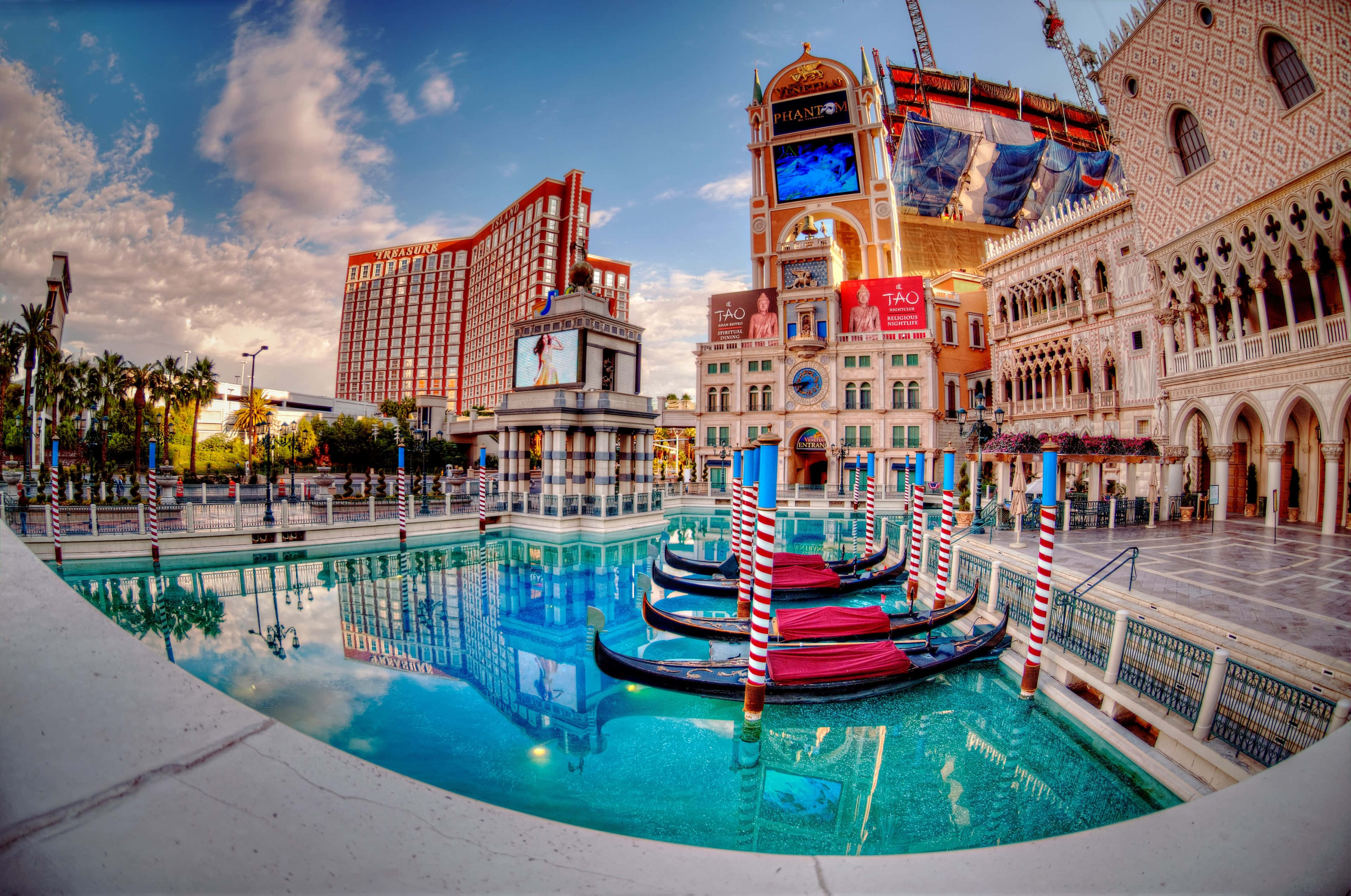 4K Las Vegas 桌布 壁紙 — 貢多拉在碧綠色的運河中漂浮，映襯著華麗的威尼斯風格建築，天空呈現出 vibrant 的日落色彩。