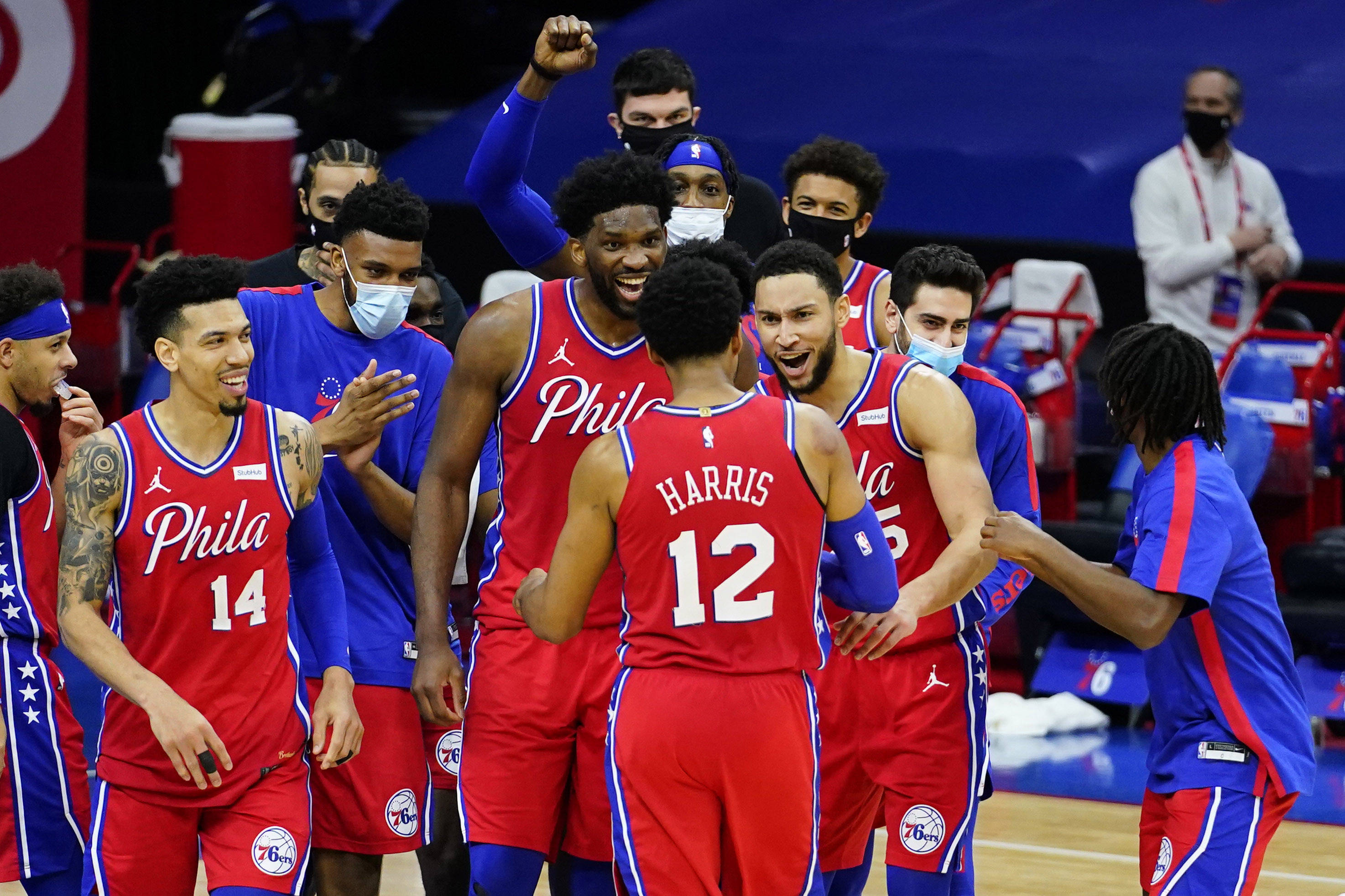 76ers 桌布 壁紙 — 費城76人籃球運動員身穿紅色球衣，在球場上高舉拳頭、帶著喜悅的表情一起慶祝。