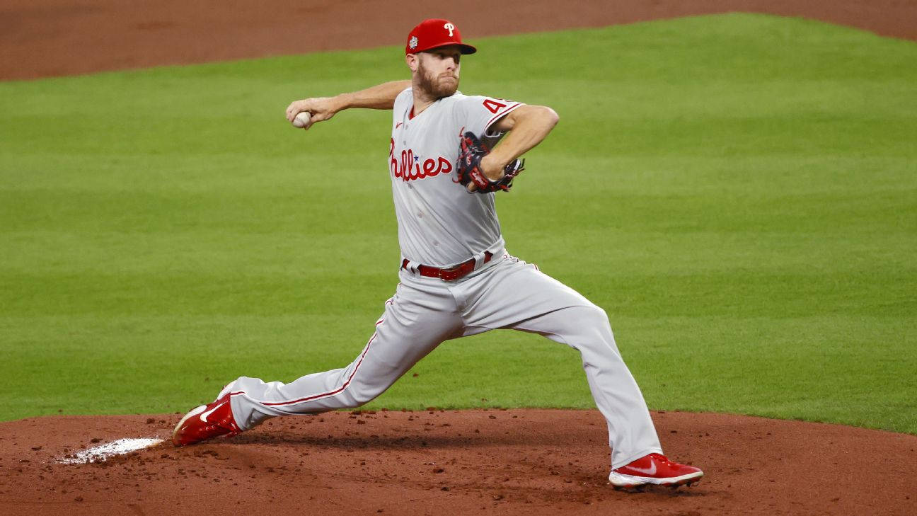 Phillies 桌布 壁紙 — 費城人投手在球場燈光下，於綠色草地和紅色泥土的棒球投手丘上投球。