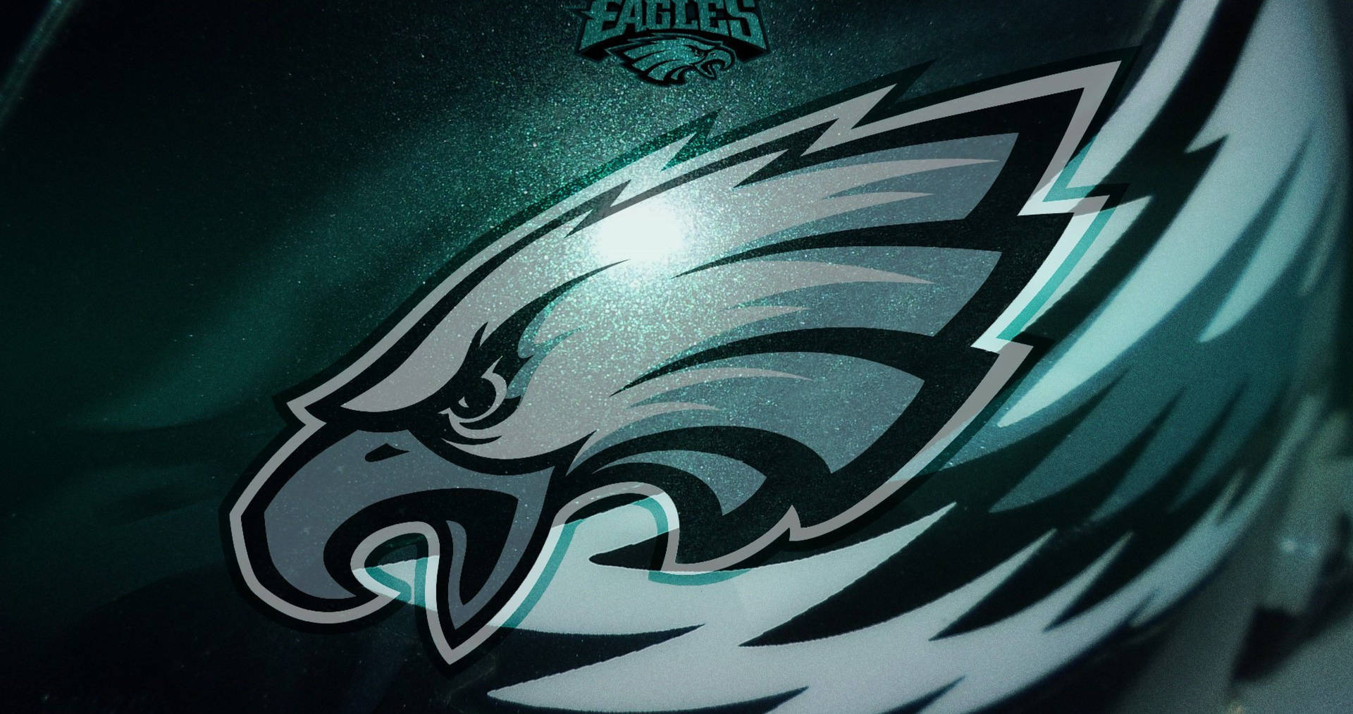 NFL Teams 桌布 壁紙 — 費城老鷹隊美式足球頭盔的特寫，在明亮的攝影棚燈光下，帶有閃閃發光的藍綠色和銀色老鷹標誌。
