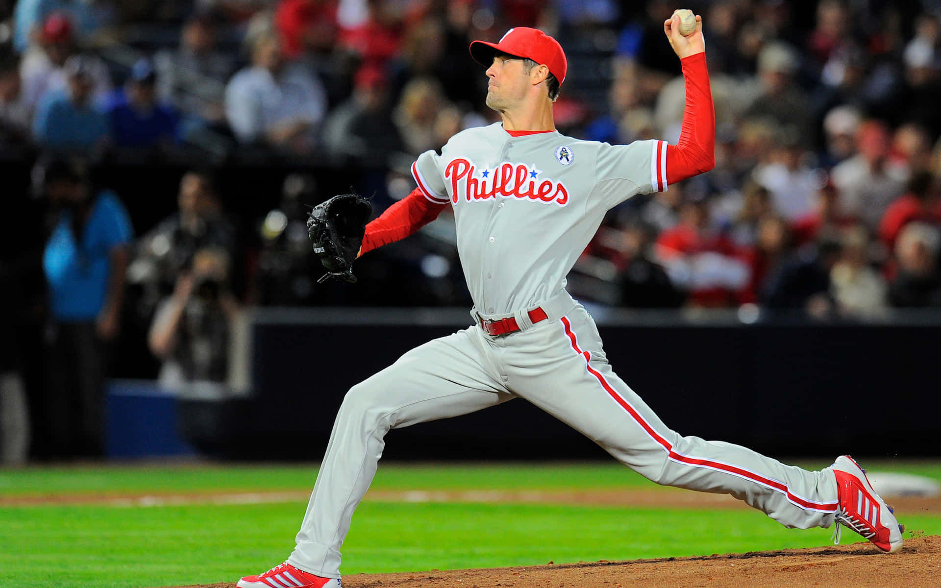 MLB Players 桌布 壁紙 — 費城費城人隊投手在夜間比賽中投球，球場燈光照亮他專注的身影。