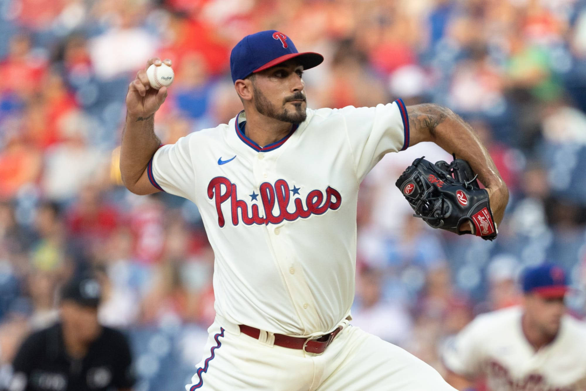Phillies 桌布 壁紙 — 費城費城人隊投手在日間棒球比賽中投球，背景有模糊的人群。