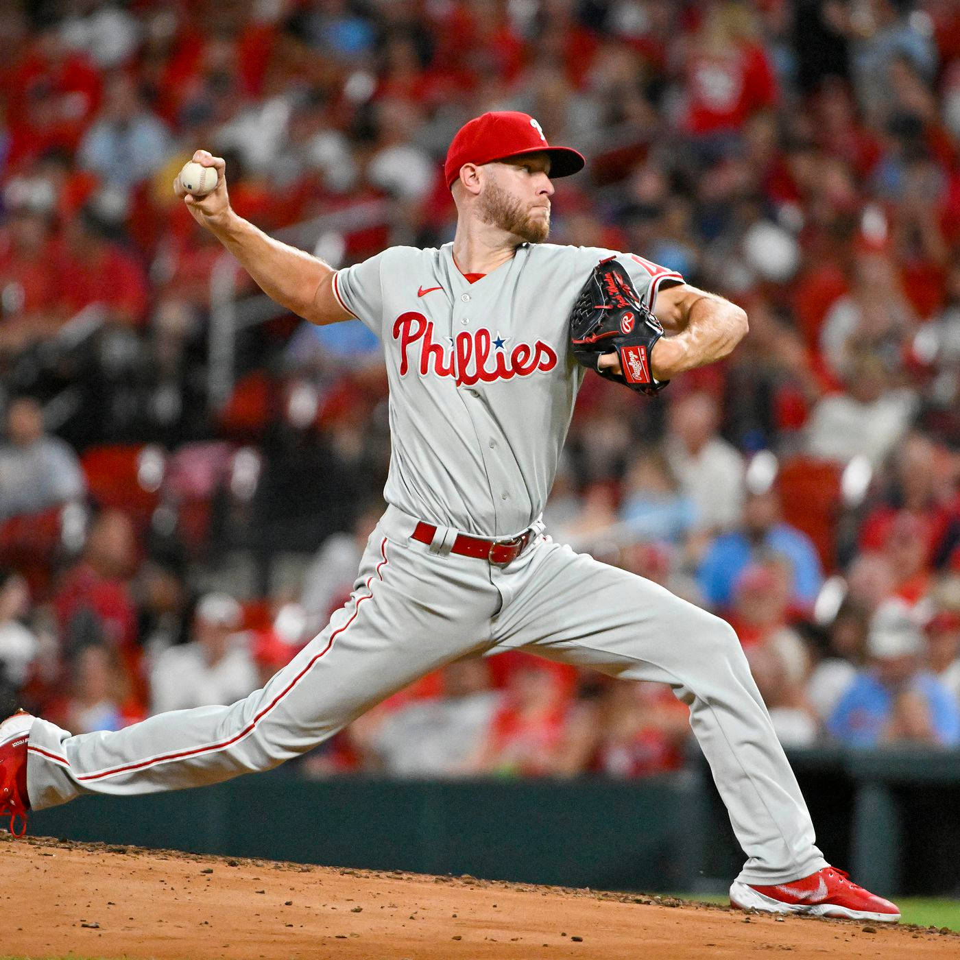 Phillies 桌布 壁紙 — 費城費城人隊投手在棒球投手丘上投球中，身後有模糊的人群坐在紅色座位上。
