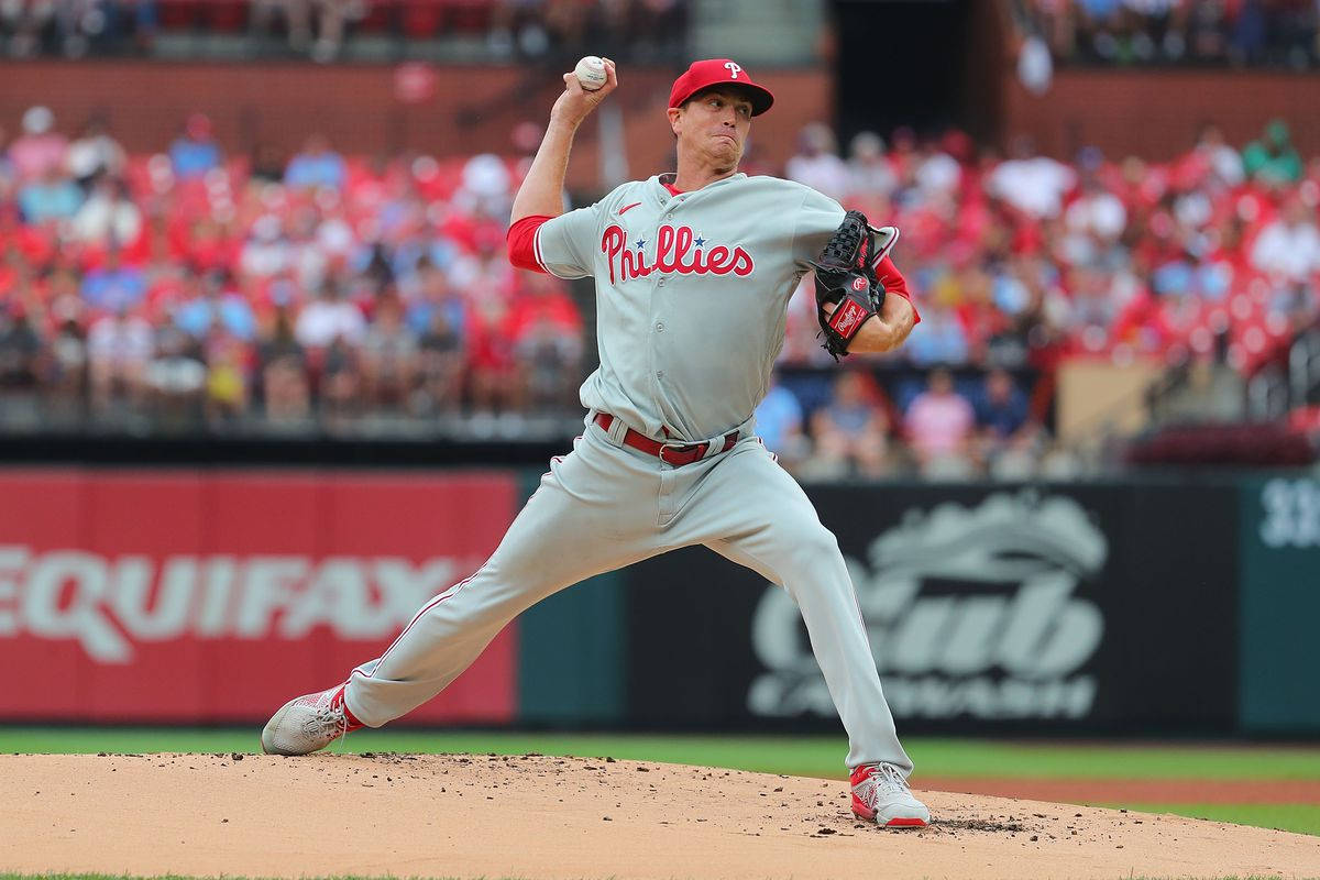 Phillies 桌布 壁紙 — 費城費城人隊投手在陽光明媚的投手丘上投球，背景是模糊的人群。