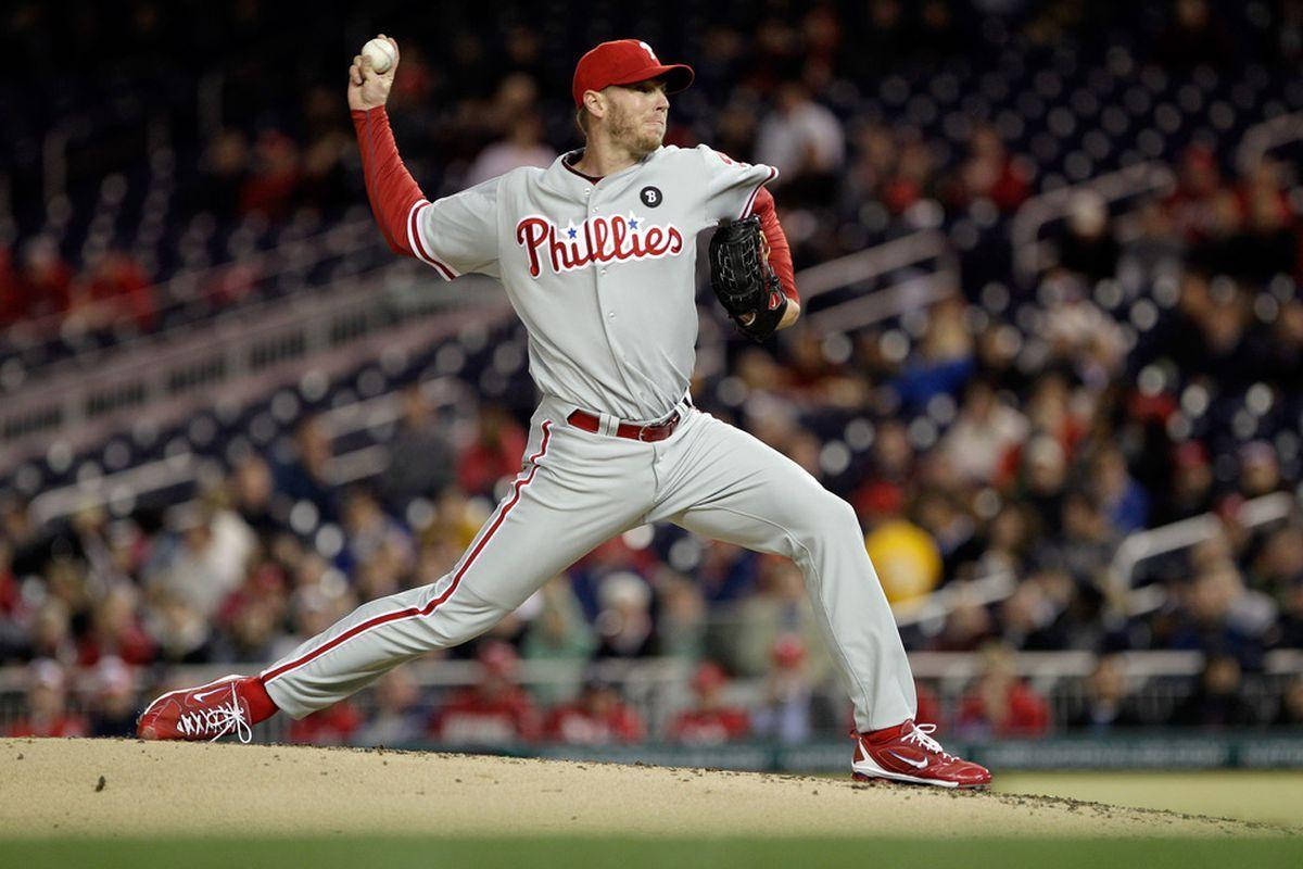 roy halladay 桌布 壁紙 — 費城費城人隊的投手在球場燈光下於投手丘上投球，背景有模糊的球迷。