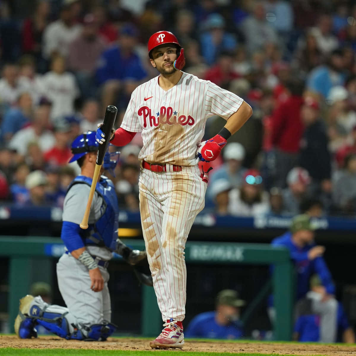 Trea Turner Phillies 桌布 壁紙 — 費城費城人隊的棒球運動員在比賽後穿著沾滿泥土的球衣，拿著球棒離開球場。