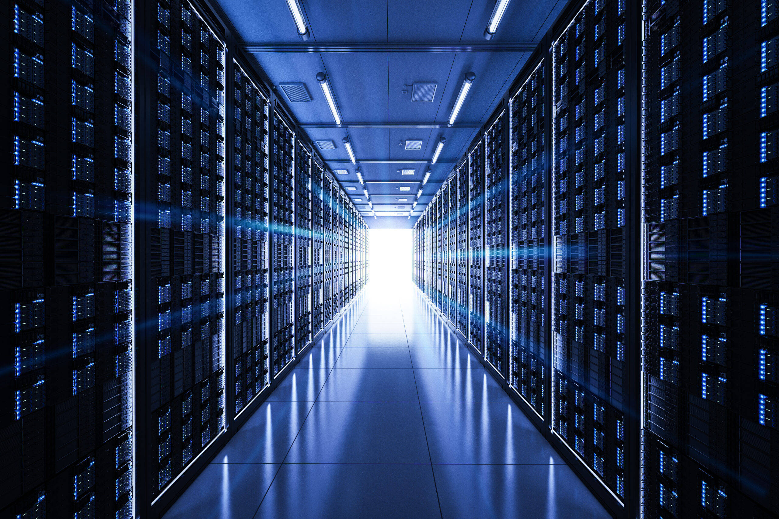 data 桌布 壁紙 — 資料中心內一條長長的伺服器機架走廊，沐浴在冷藍色燈光中，遠端有明亮的白色光芒。