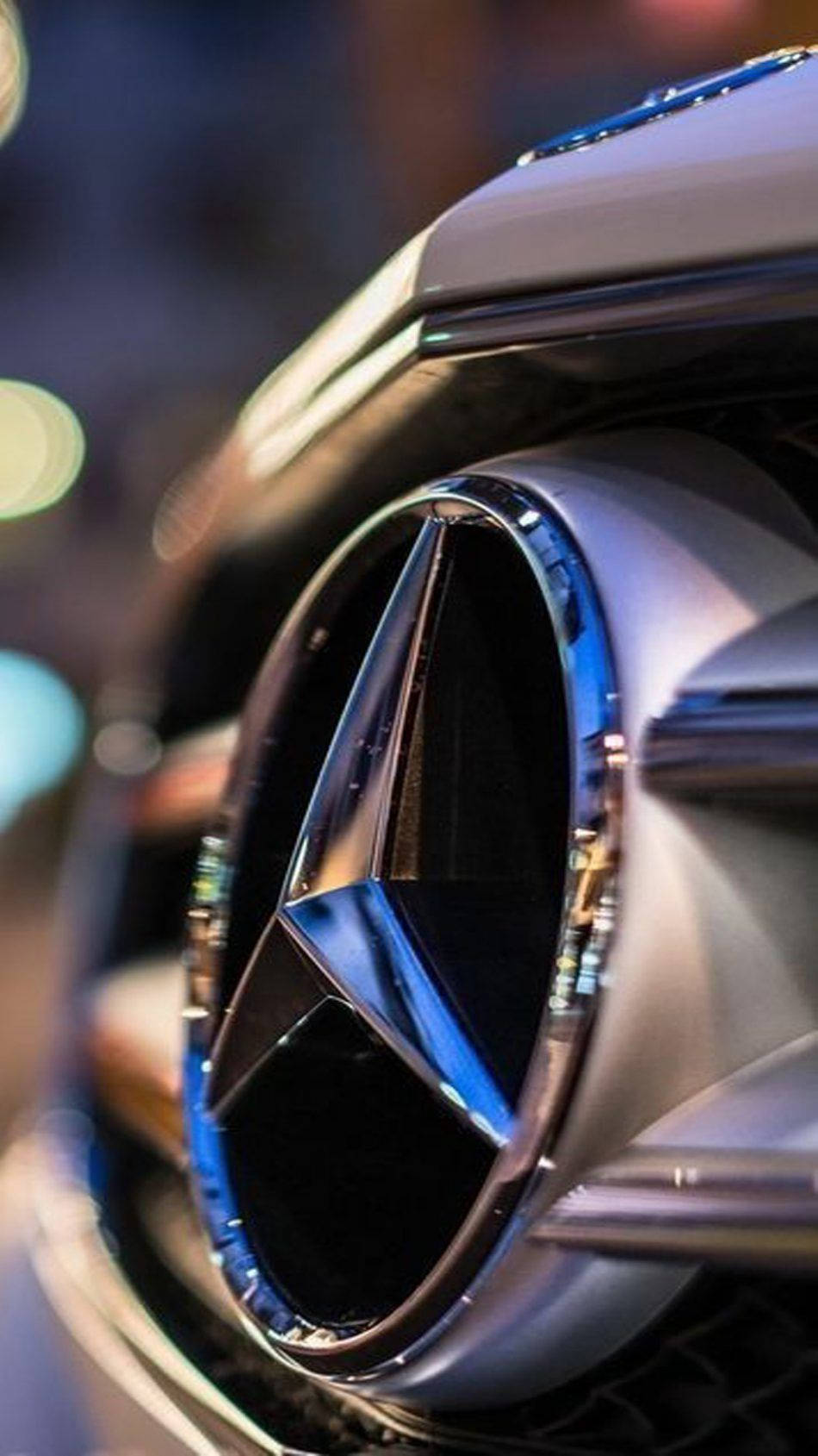 Mercedes 桌布 壁紙 — 賓士標誌特寫，在夜燈下閃爍，背景呈散景效果。