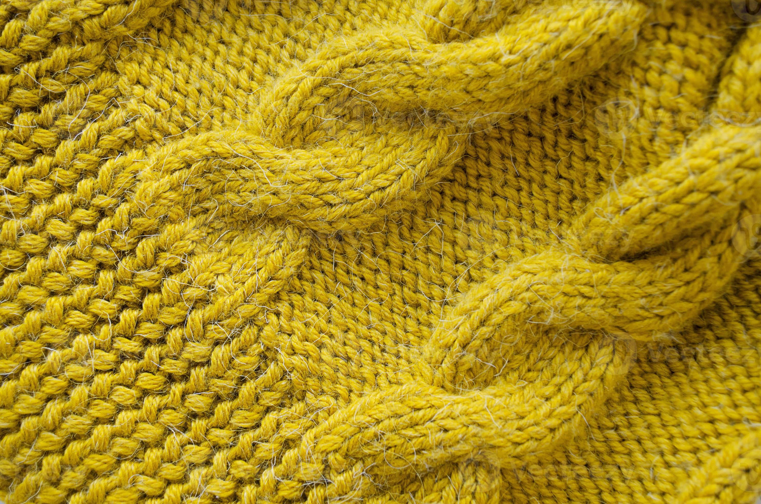 clothing 桌布 壁紙 — 質感芥末黃色針織布料的特寫，帶有纜繩圖案和柔軟纖維。