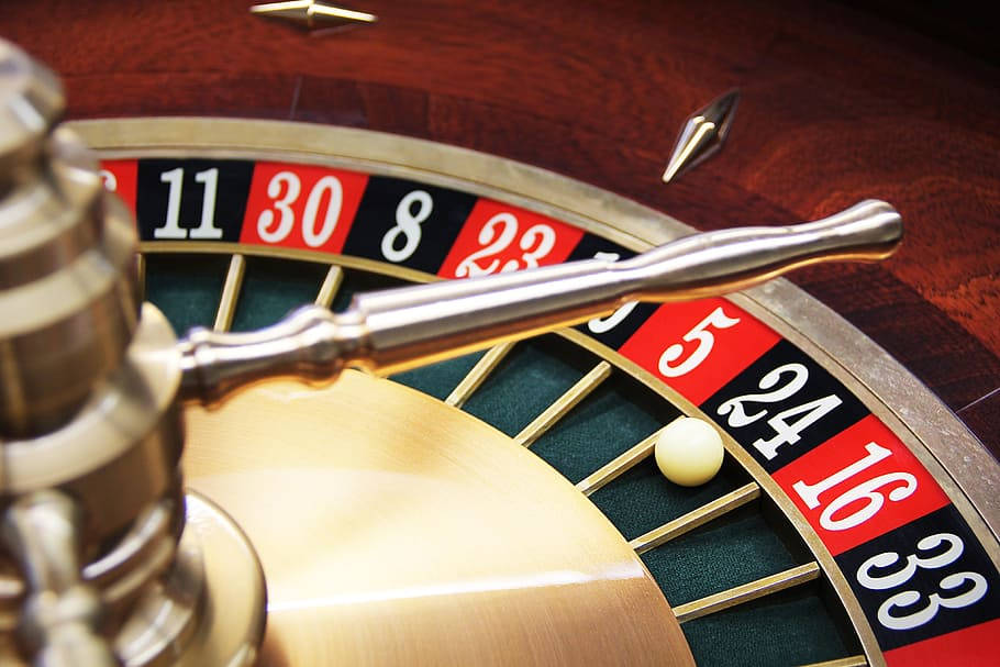Casino 桌布 壁紙 — 賭場輪盤特寫，白色球停在5號上，金屬手柄清晰對焦。