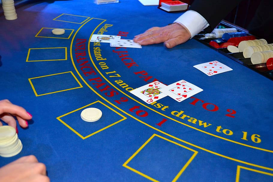 Casino 桌布 壁紙 — 賭場遊戲中藍色二十一點桌上紙牌與籌碼的特寫。