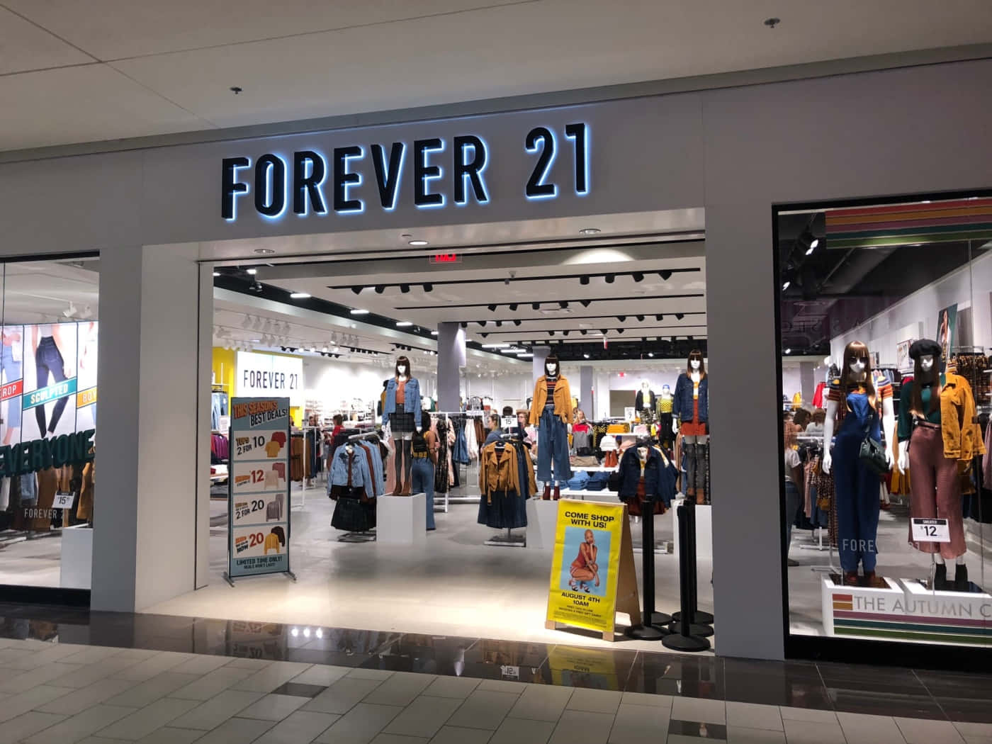 永遠21 桌布 壁紙 — 購物中心內一間Forever 21店鋪入口燈光明亮，展示身穿秋季時裝的人體模型及特價標誌。
