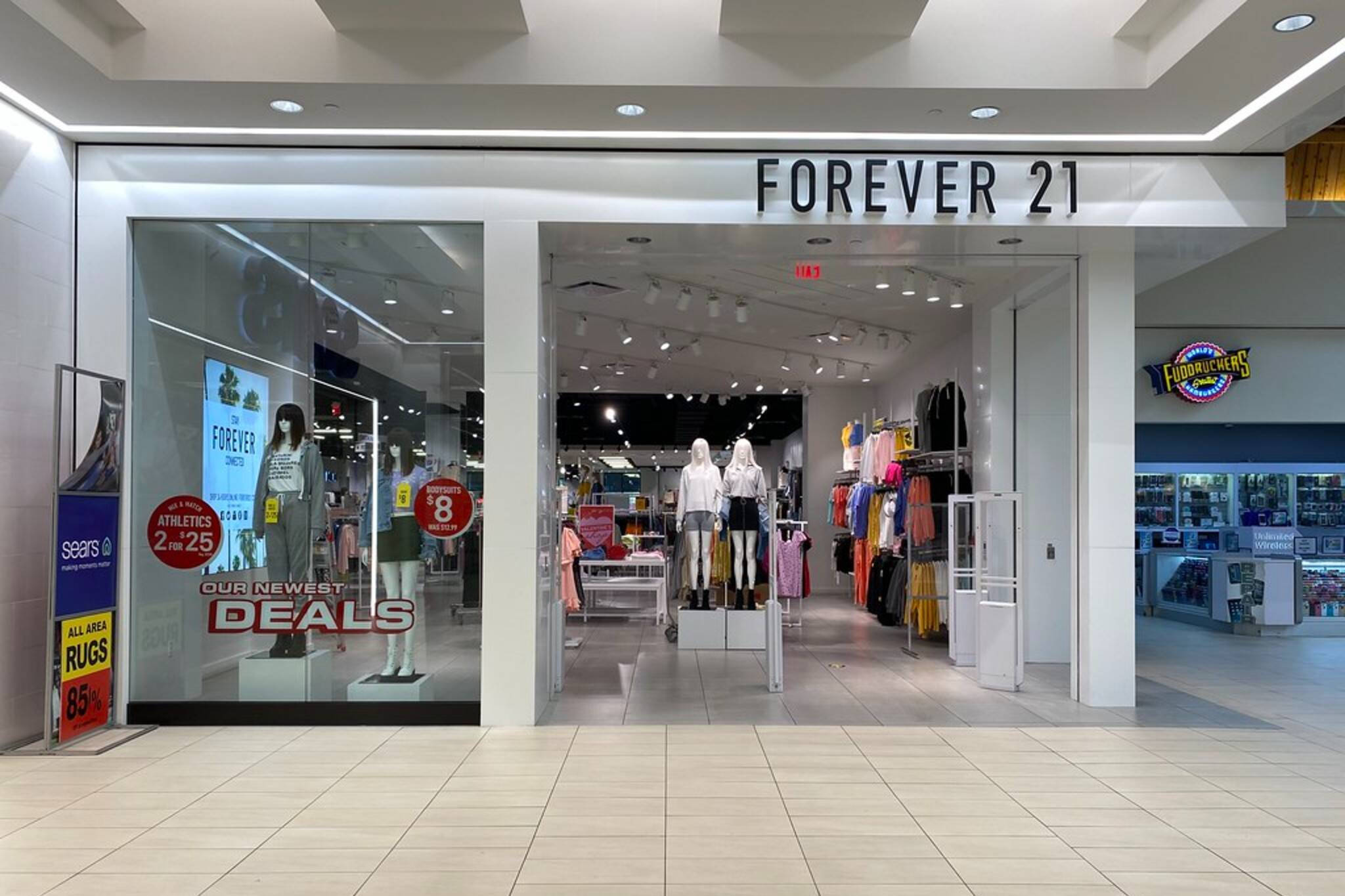 永遠21 桌布 壁紙 — 購物中心內一間燈光明亮的Forever 21商店入口，人體模型展示服裝和促銷優惠標誌。