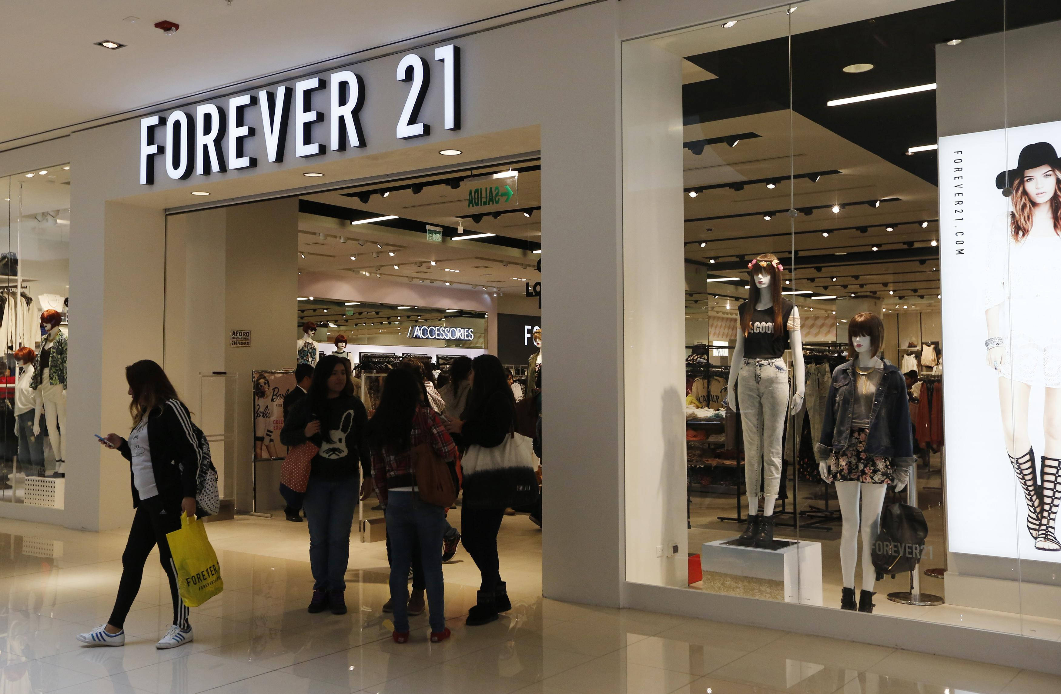 Forever 21 桌布 壁紙 — 購物者在光線明亮的購物中心內，在Forever 21商店外瀏覽，櫥窗內的人體模型展示著時尚服裝。