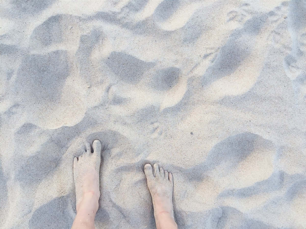 sand 桌布 壁紙 — 赤腳陷入柔軟有紋理的沙中，在柔和自然光下。