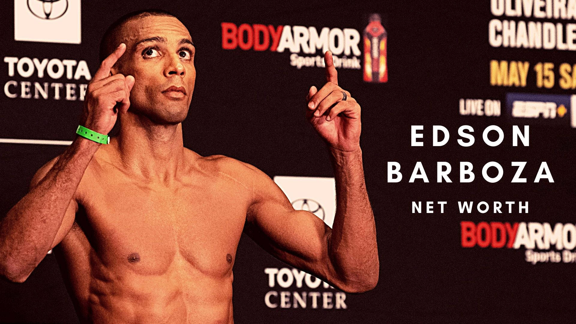 MMA 桌布 壁紙 — 赤裸上身的拳手 Edson Barboza 雙手指向上方，背景為品牌記者會背景板。