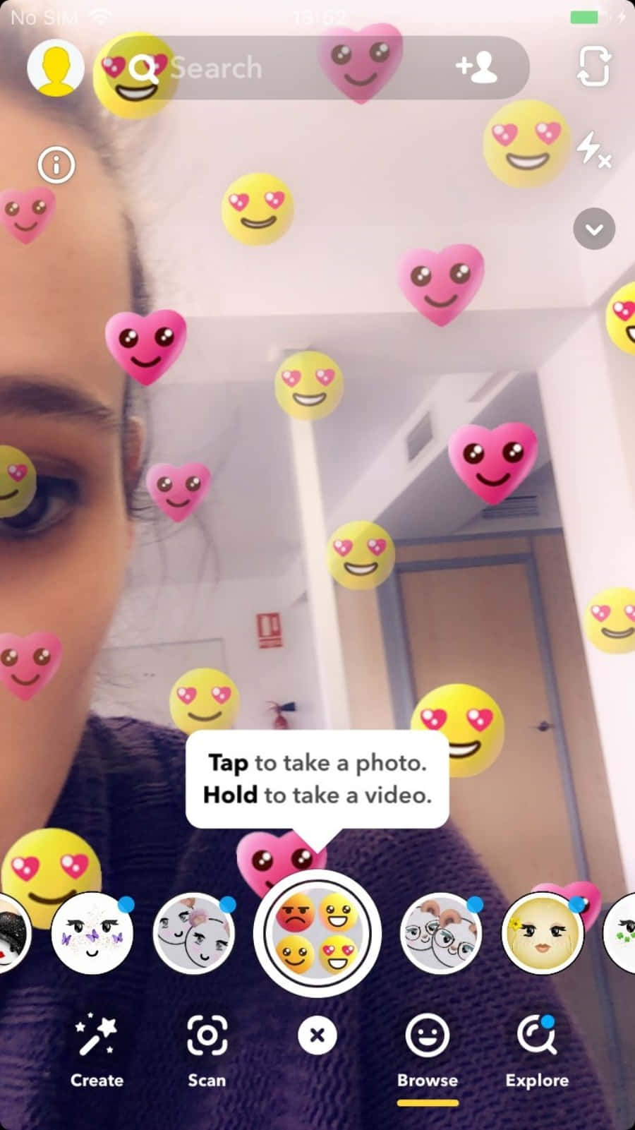 Snapchat 桌布 壁紙 — 走廊中一個人身上疊加漂浮的粉紅色心形和黃色笑臉表情符號的自拍。