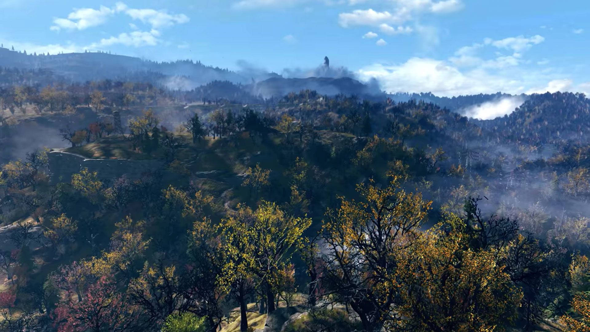 Fallout 76 桌布 壁紙 — 起伏的秋日山丘，覆蓋著金色和深紅色的樹木，在明亮的藍天下有縷縷白雲。