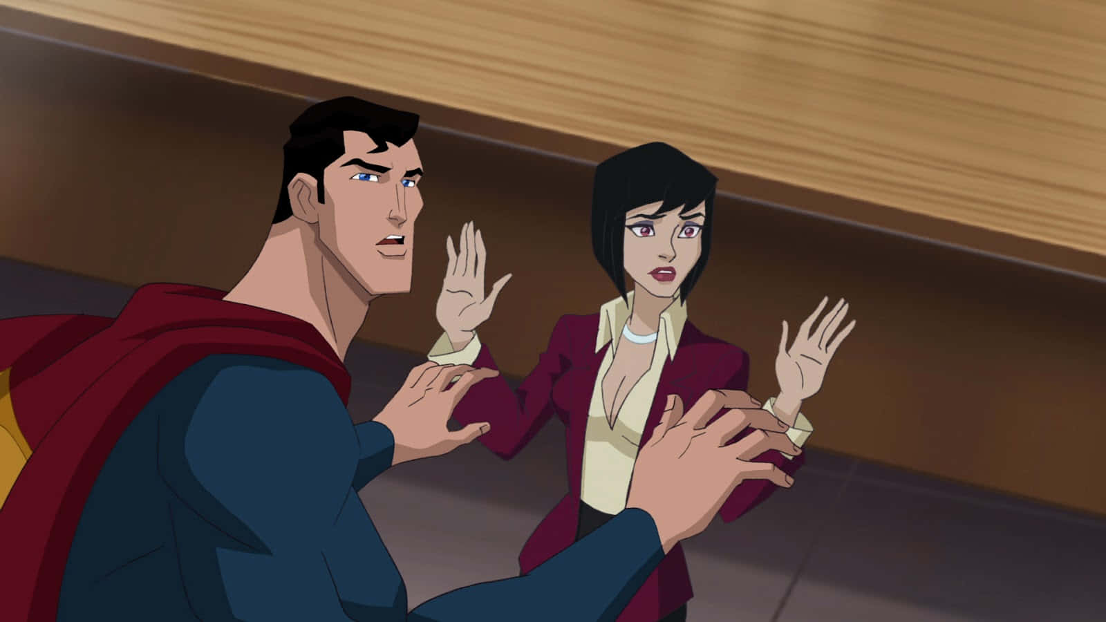 Superman Unbound 桌布 壁紙 — 超人和一位穿著棗紅色西裝外套的女性在光線昏暗、天花板有木質面板的走廊裡急切地做手勢。