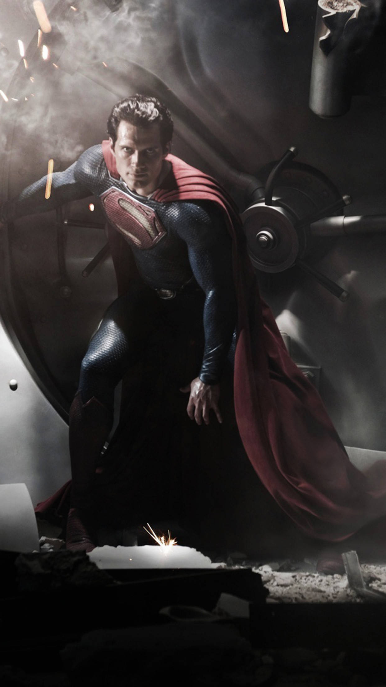 superman iPhone 桌布 壁紙 — 超人挑釁地站在一個破碎的工業環境中，火花四濺，煙霧瀰漫。