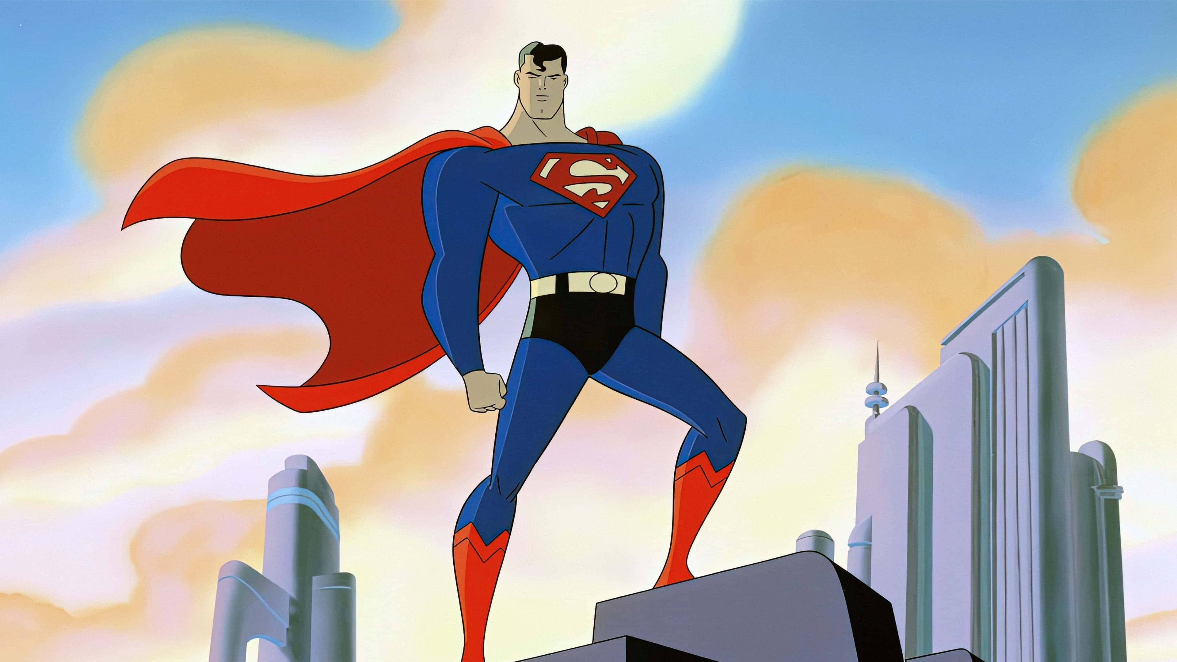 Superman The Animated Series 桌布 壁紙 — 超人英雄式地站在摩天大樓頂端，紅色斗篷在夕陽天空下飄揚。