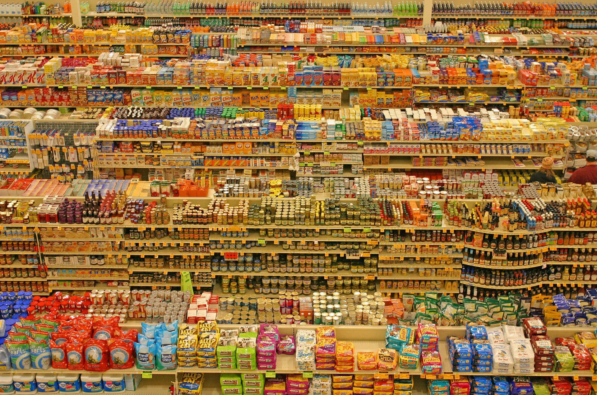 supermarket 桌布 壁紙 — 超市通道的鳥瞰圖，擺滿色彩繽紛的罐頭、玻璃罐和零食包裝，形成充滿活力的圖案。