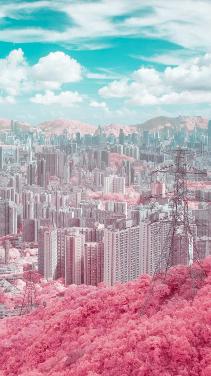 動漫城市 桌布 壁紙 — 超現實的城市景觀，粉紅色的森林和藍綠色的天空俯瞰著密集的城市建築。