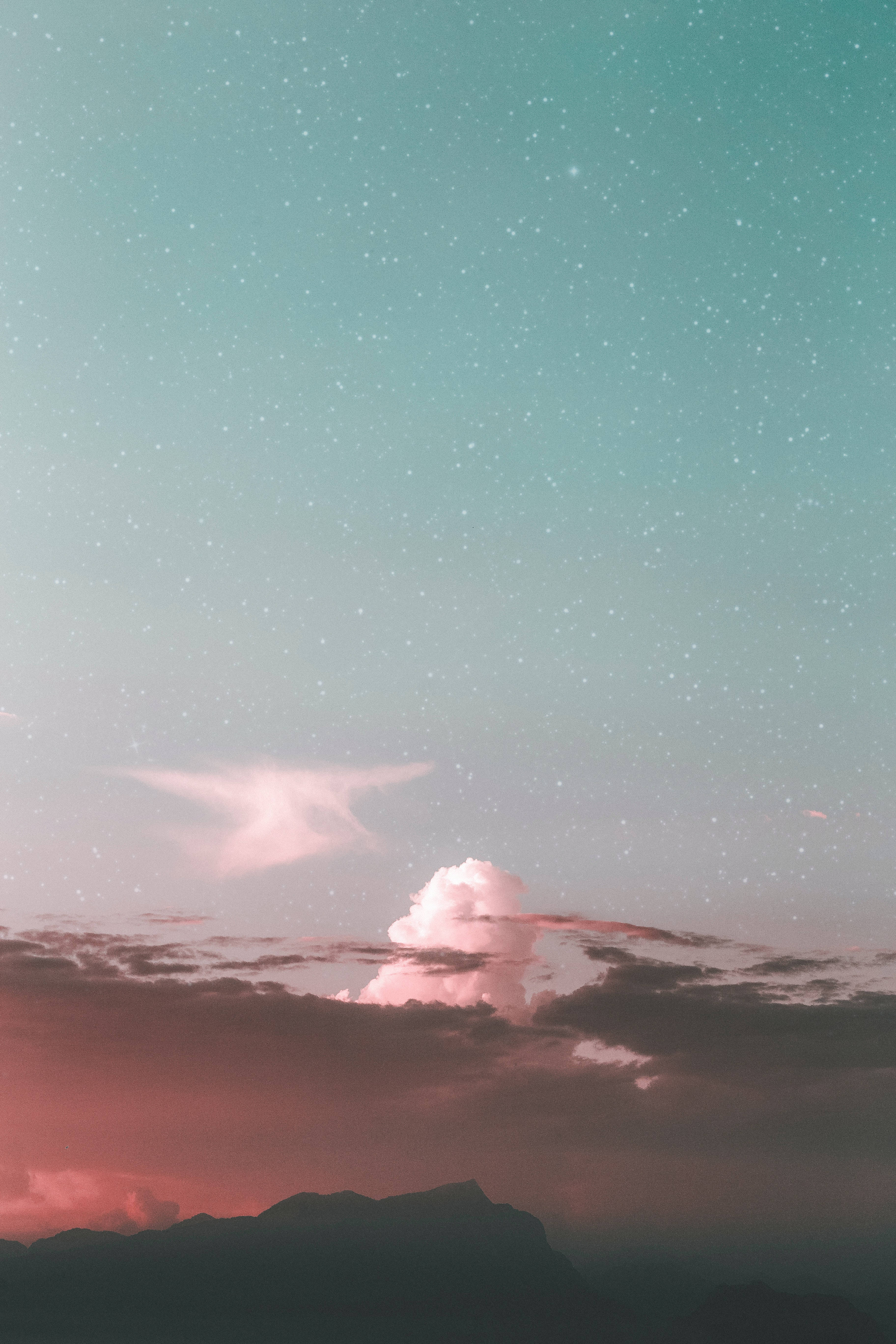 綠色天空 桌布 壁紙 — 超現實的黃昏天空，粉紅色的雲和星星在黑暗的山脈輪廓之上。