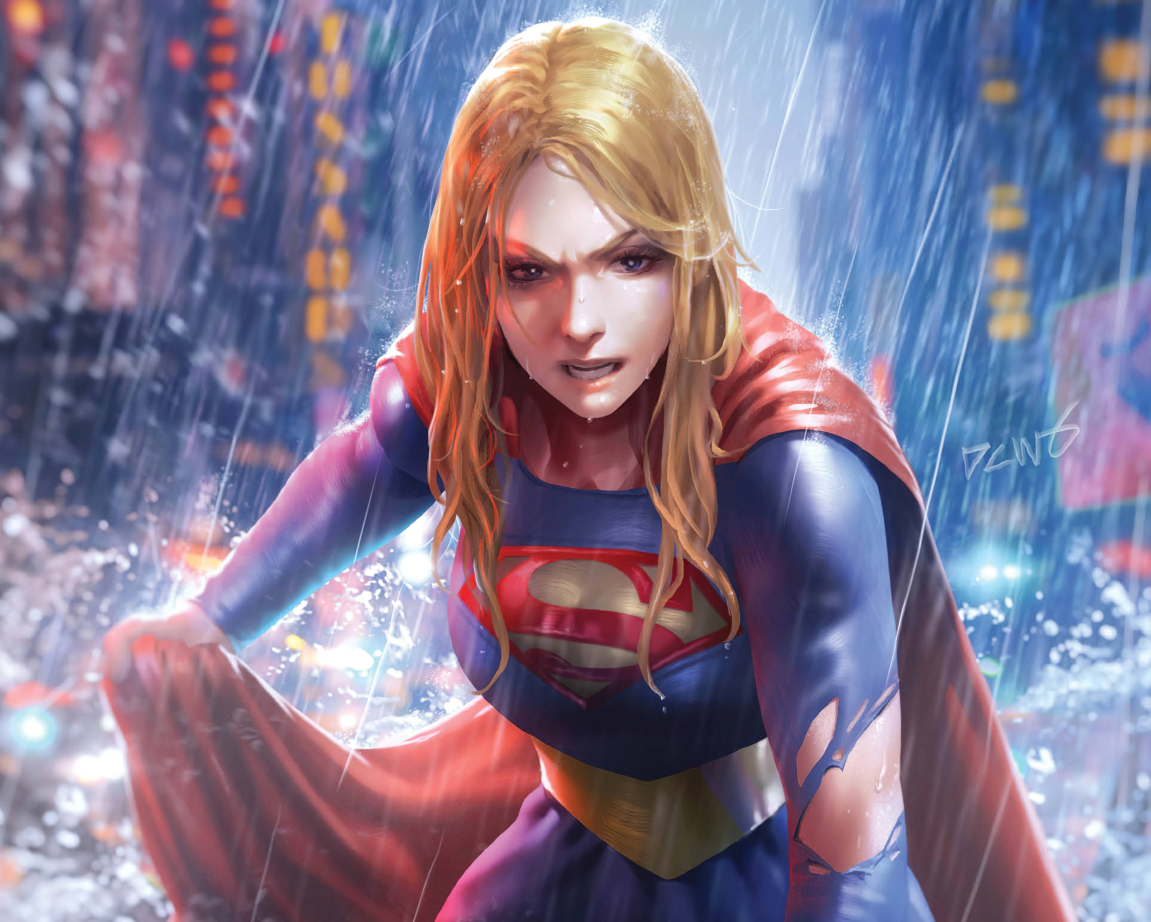Supergirl 桌布 壁紙 — 超級女孩在雨浸的城市景觀中挑釁地站立，她的紅色斗篷飄揚，霓虹燈在她身後濕漉漉的瀝青上反射。