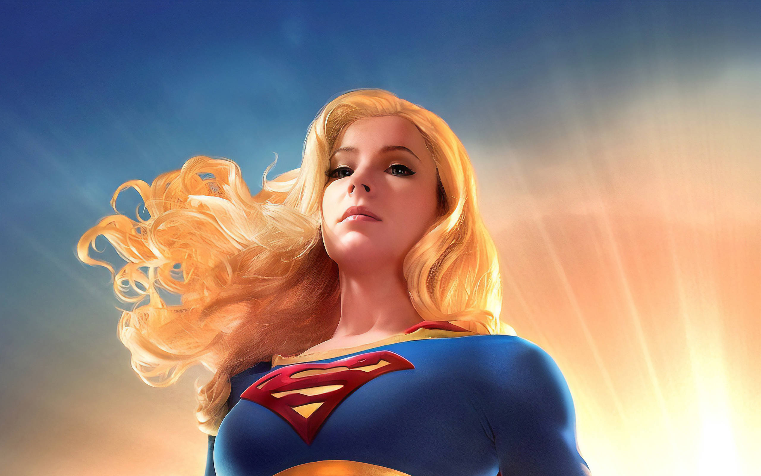 Supergirl 桌布 壁紙 — 超級女孩英勇地站在燦爛的天空下，金色頭髮飄揚，陽光在她身後爆發。